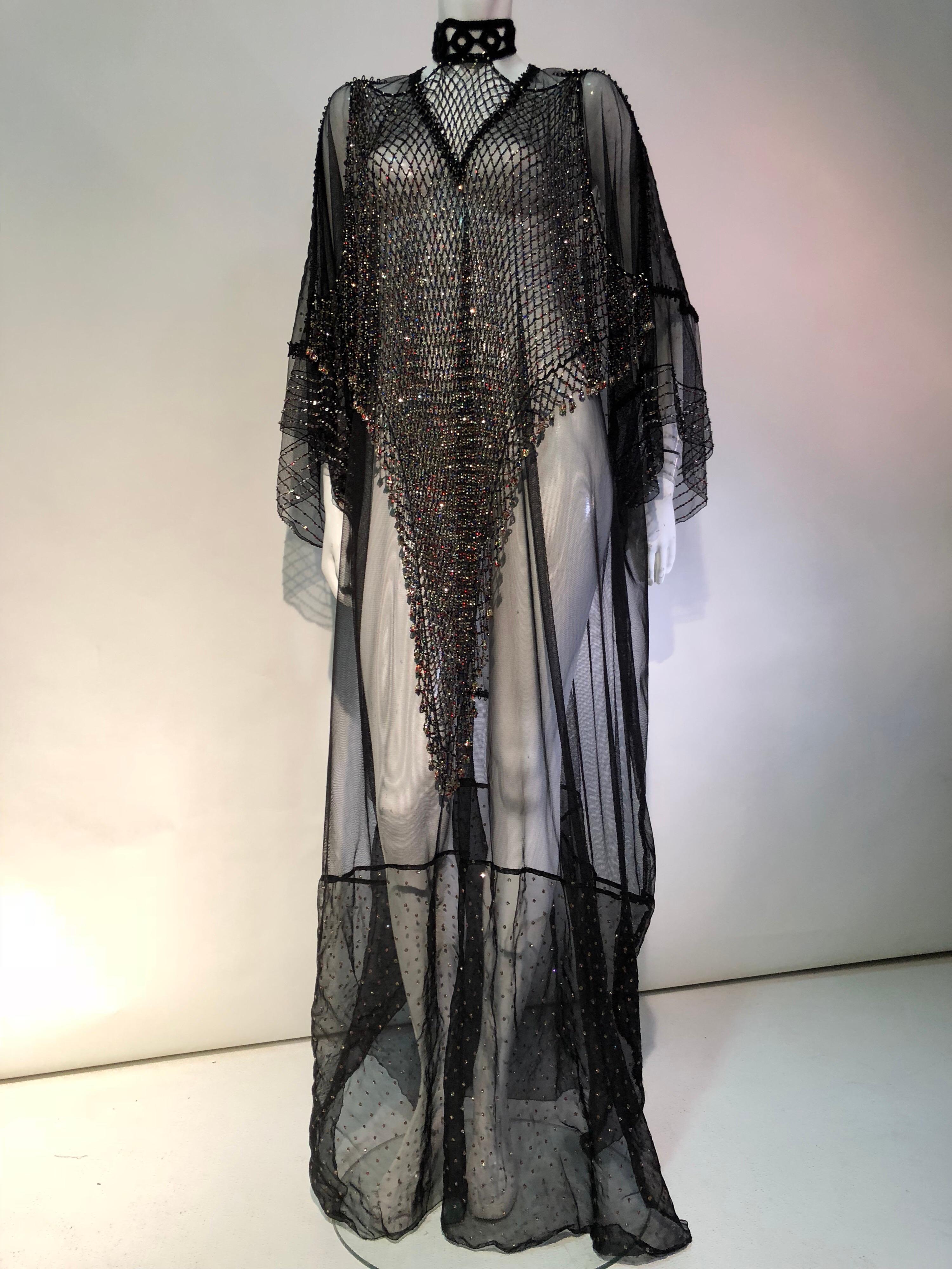 Featured here is a glorious custom made black net and vintage speckled sheer fabric Kaftan designed with a dramatic beaded net bib front choker necklace that ties at the neck and is attached to the Kaftan at the shoulders . Sequin and beaded sleeves