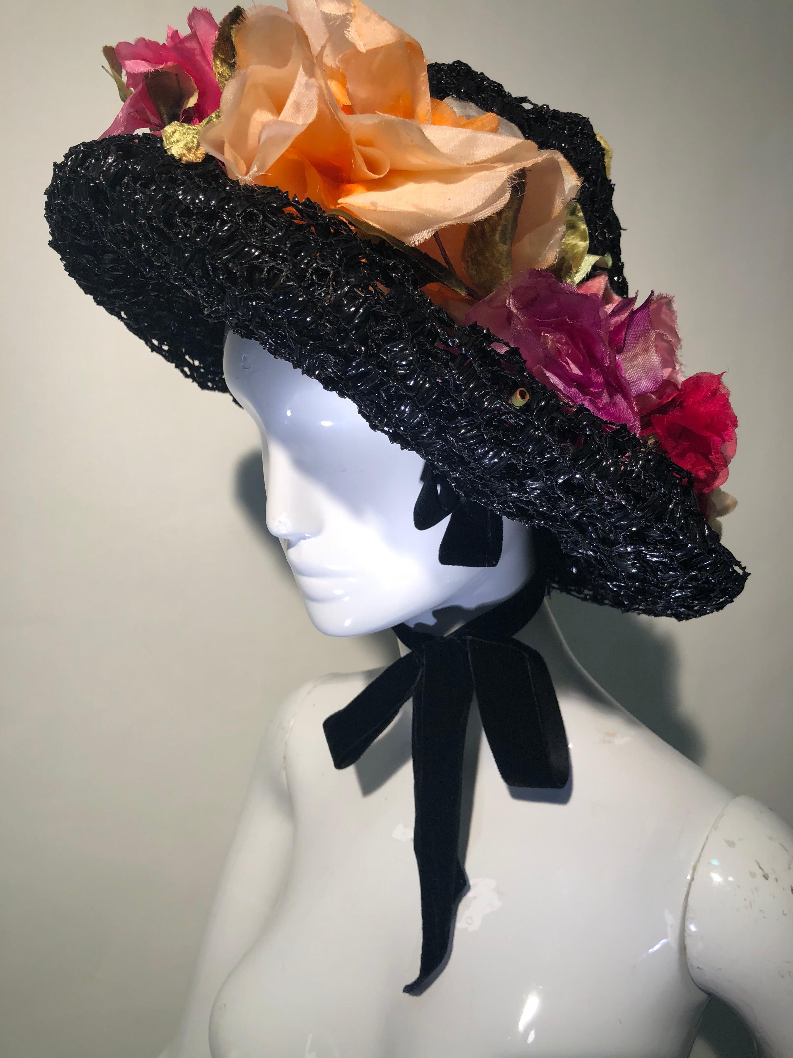 This superb couture 1950s Irina Roublon multi-color, silk floral trimmed hat is a hand-made beauty. Multiple layers of lacquered black veiling make up the body with a soft-peaked crown. So chic! Hat is secured by ribbon tie behind ears.  