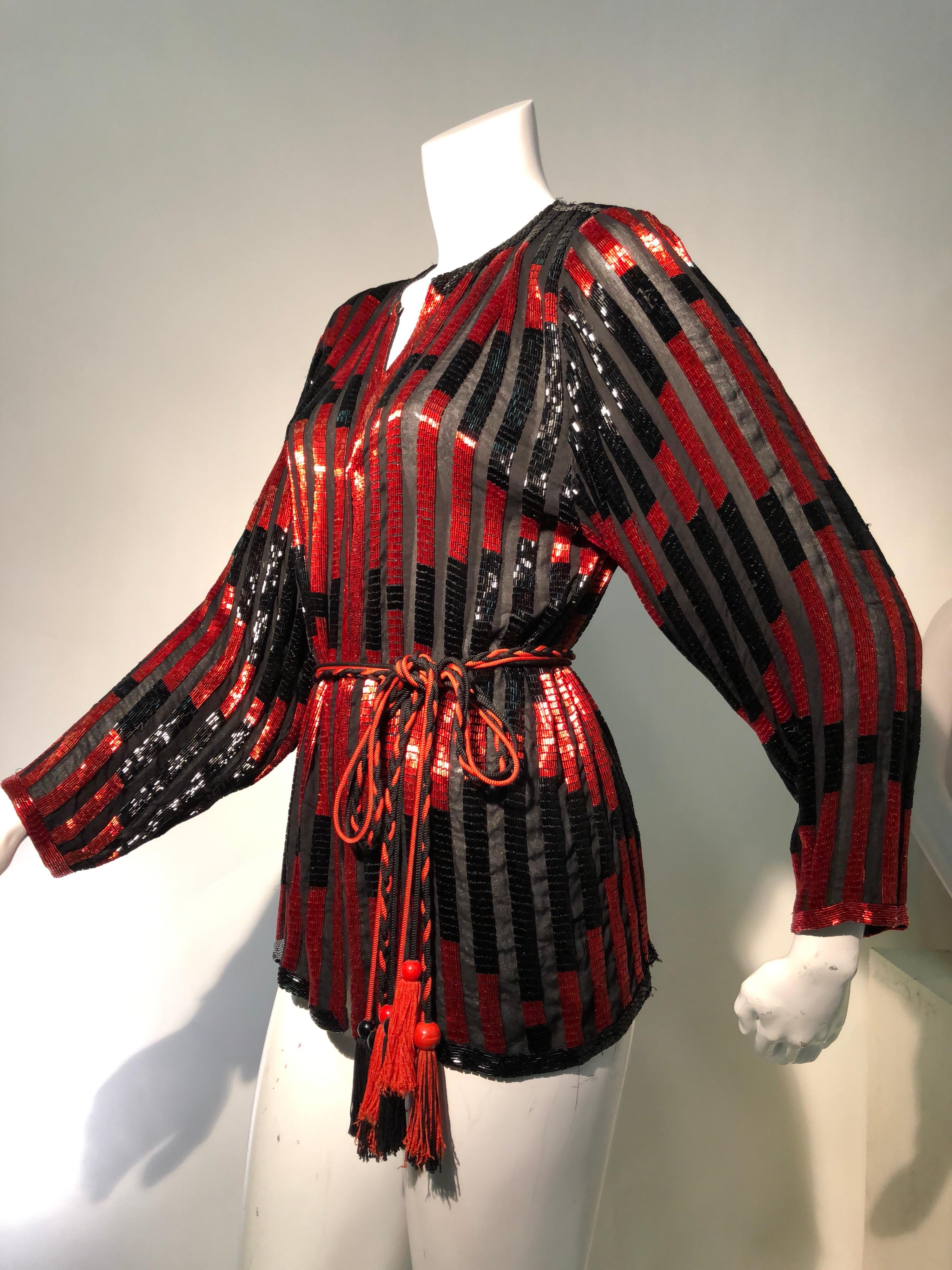 A luxe 1970s tunic top of silk chiffon with alternating stripes of red and black glass bugle beads. Bead tassel belt of twisted cord. Front hook and eye closures: can also be worn as jacket. Unlabeled.