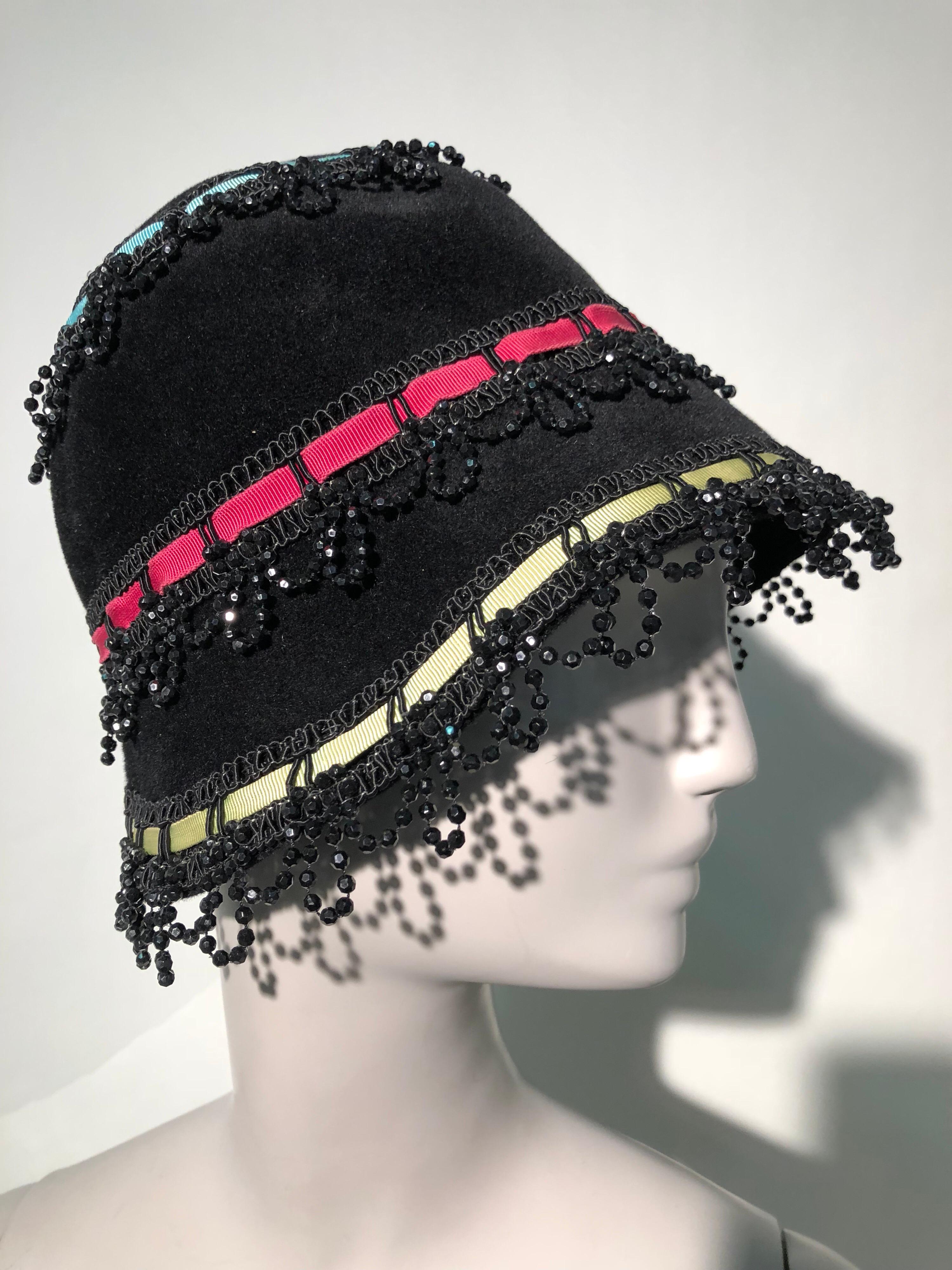 A wonderfully whimsical 1960s Yves Saint Laurent black felt bucket hat with red, yellow and pale blue grosgrain ribbons threaded through resin bead looped trim. Medium size.