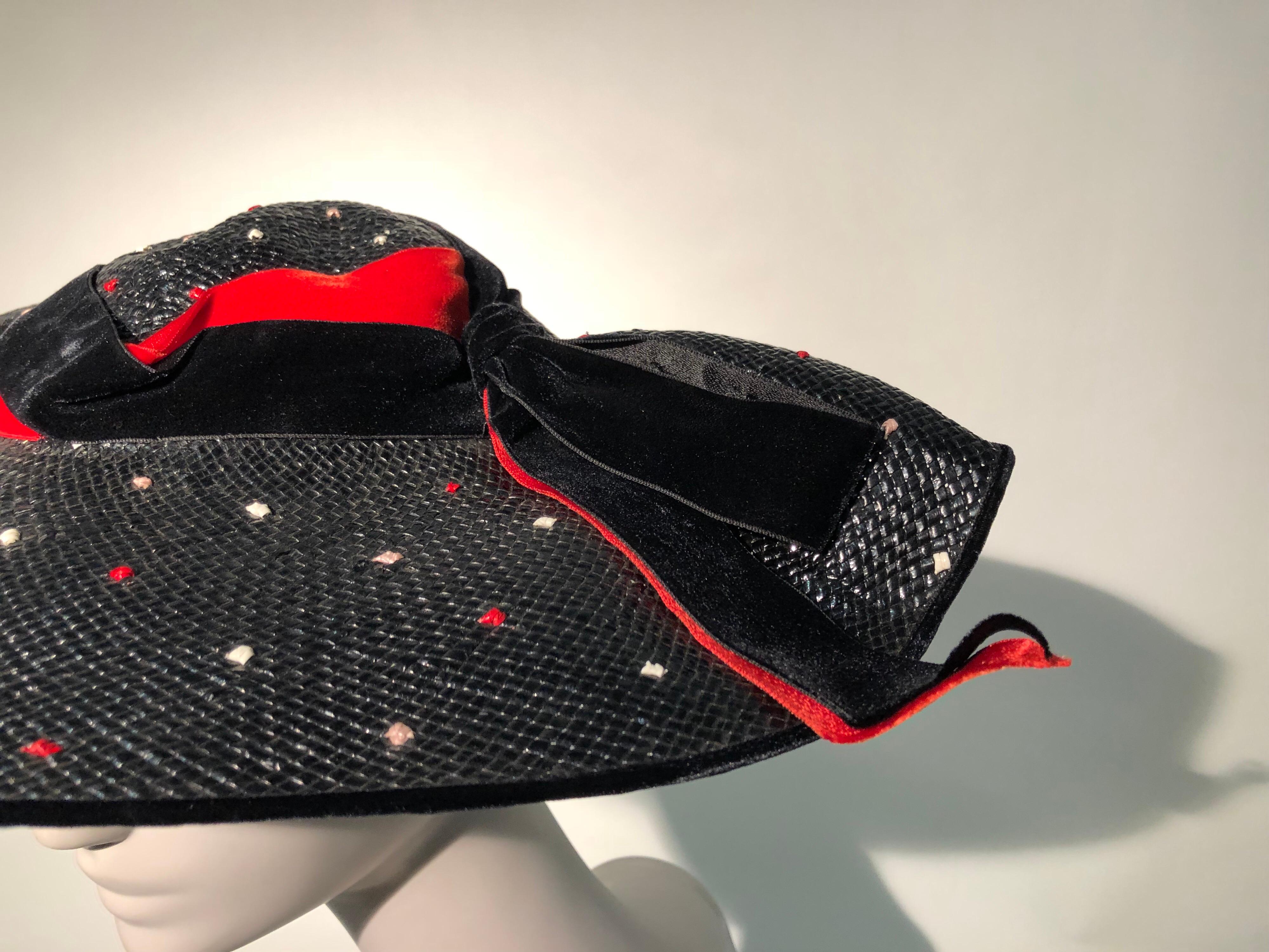 A gorgeous 1950s Casper Davis platter hat in black straw picked all over with red and white dots. The softly undulating sculpted brim is trimmed with beautiful red and black velvet ribbon. One-size fits all style.