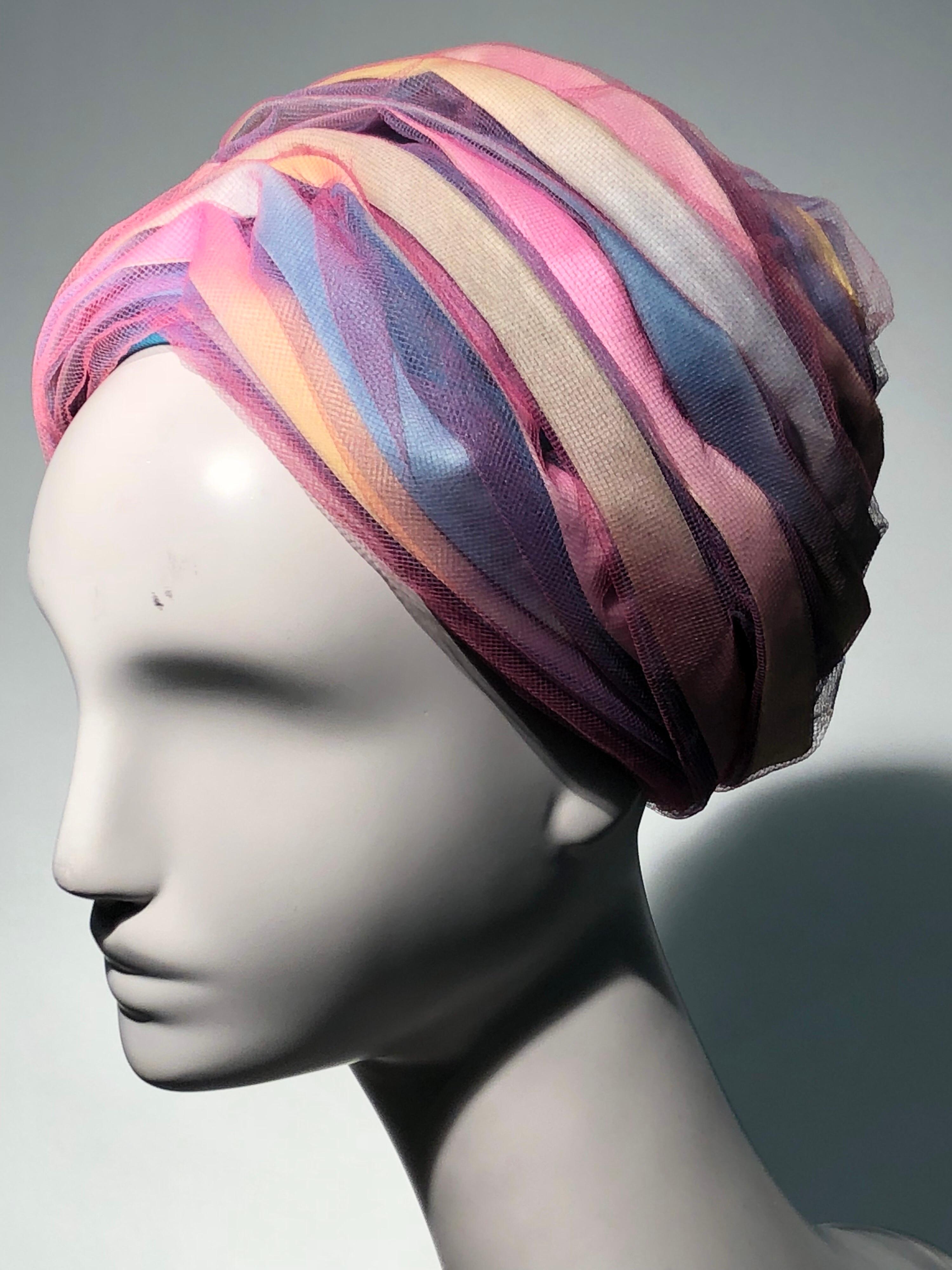 A wonderful 1960s Christian Dior turban-style beehive hat with pastel color silk ribbon multicolor satin stripes covered in purple silk tulle. One-Size.