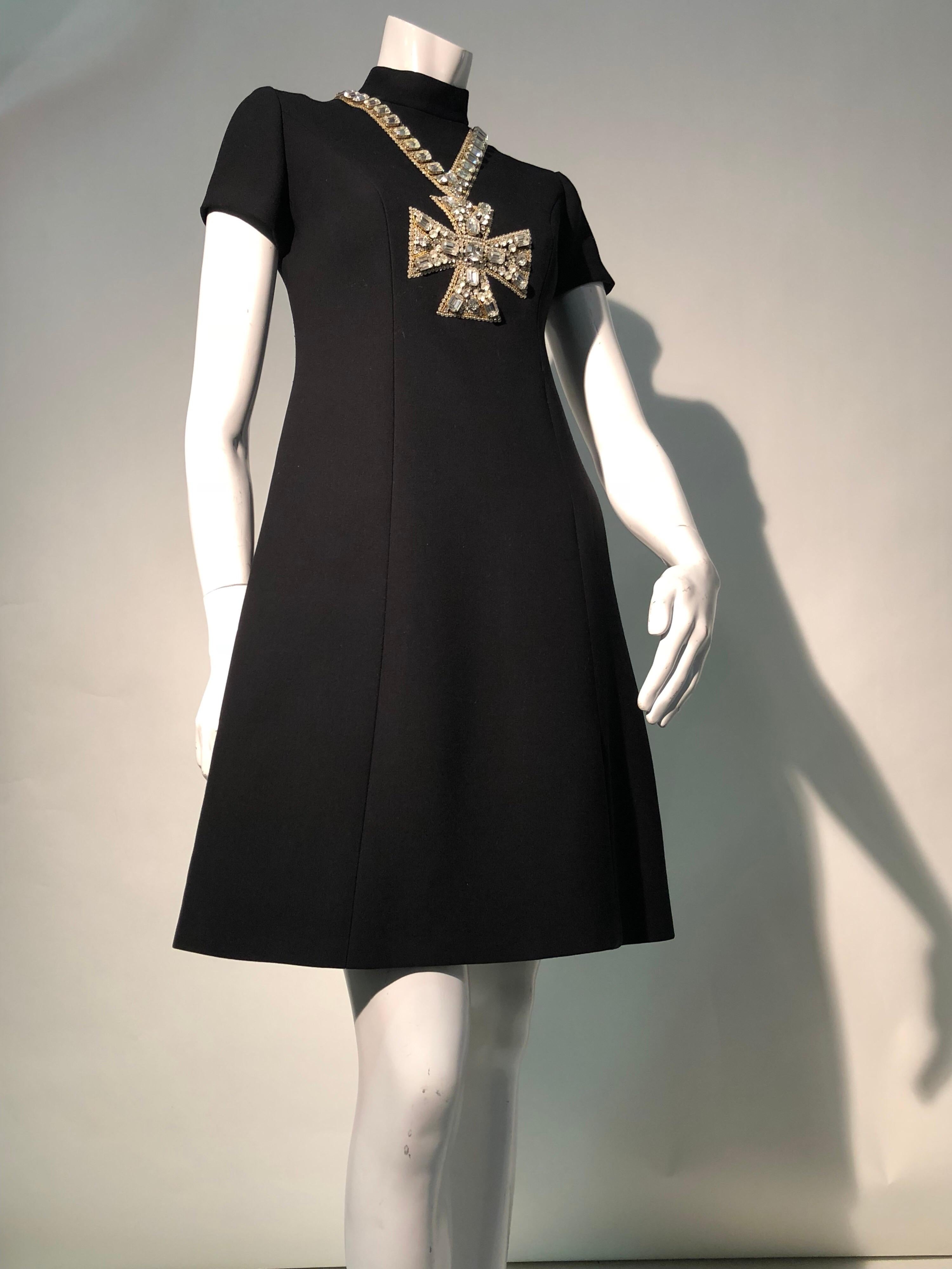 An exquisite 1968 Mod Norman Norell for I. Magnin black wool gabardine A-line mini dress with large rhinestone embroidered trompe l'oeil cross necklace. Back zipper. Cap sleeves. Silk lined.