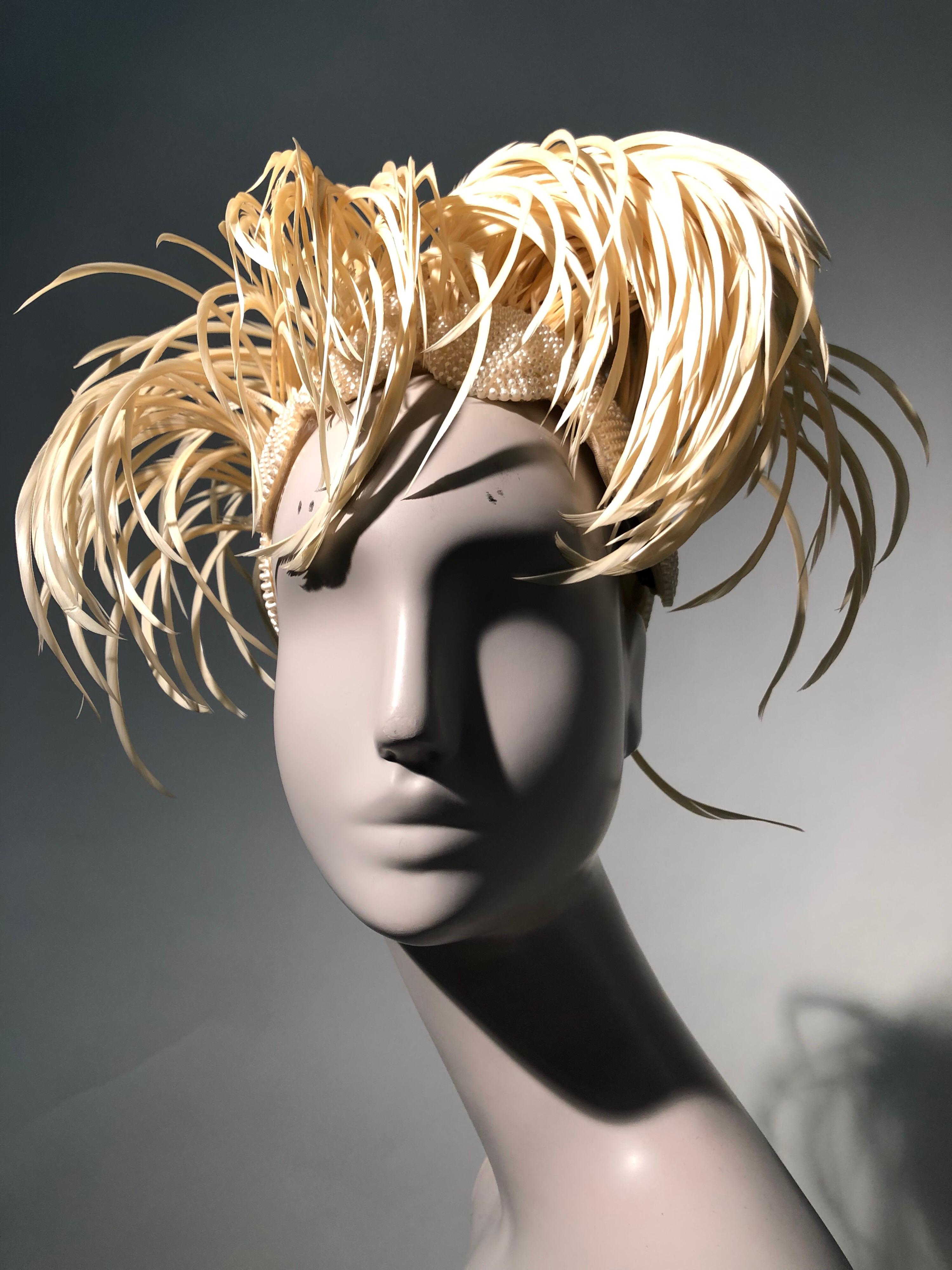 A fabulous and rare 1950s Bes-Ben cream exotic feather and faux pearl medallion hat. Couture-style soft construction with organza lining.  With their signature whimsical style, Bes-Ben creates a knock-out statement.