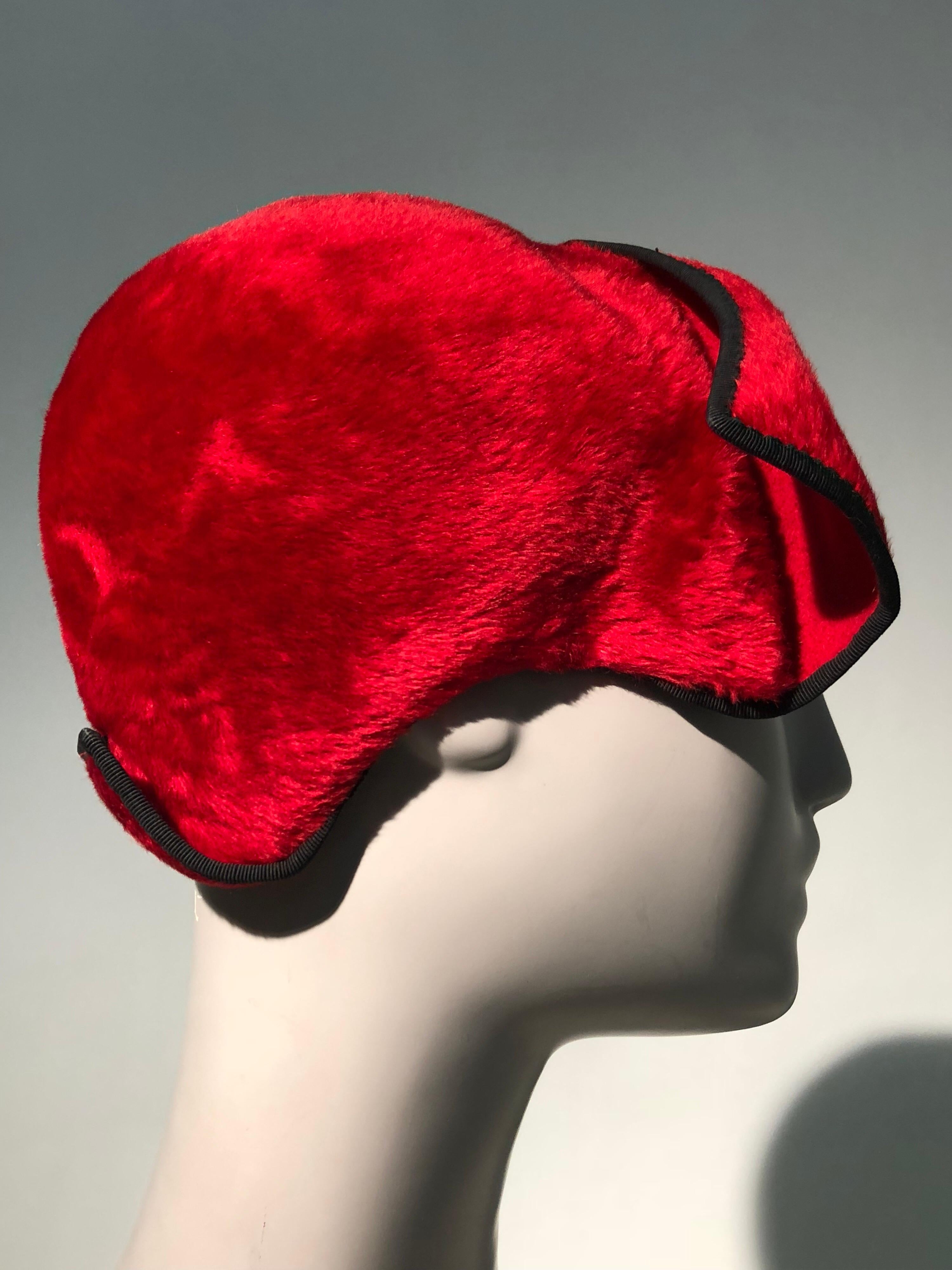An unusual 1950s John Frederics red fur felt close-fitting cloche cap with black  binding at edges and turned back corners cut into the form at front and back.  Size Small to Medium.