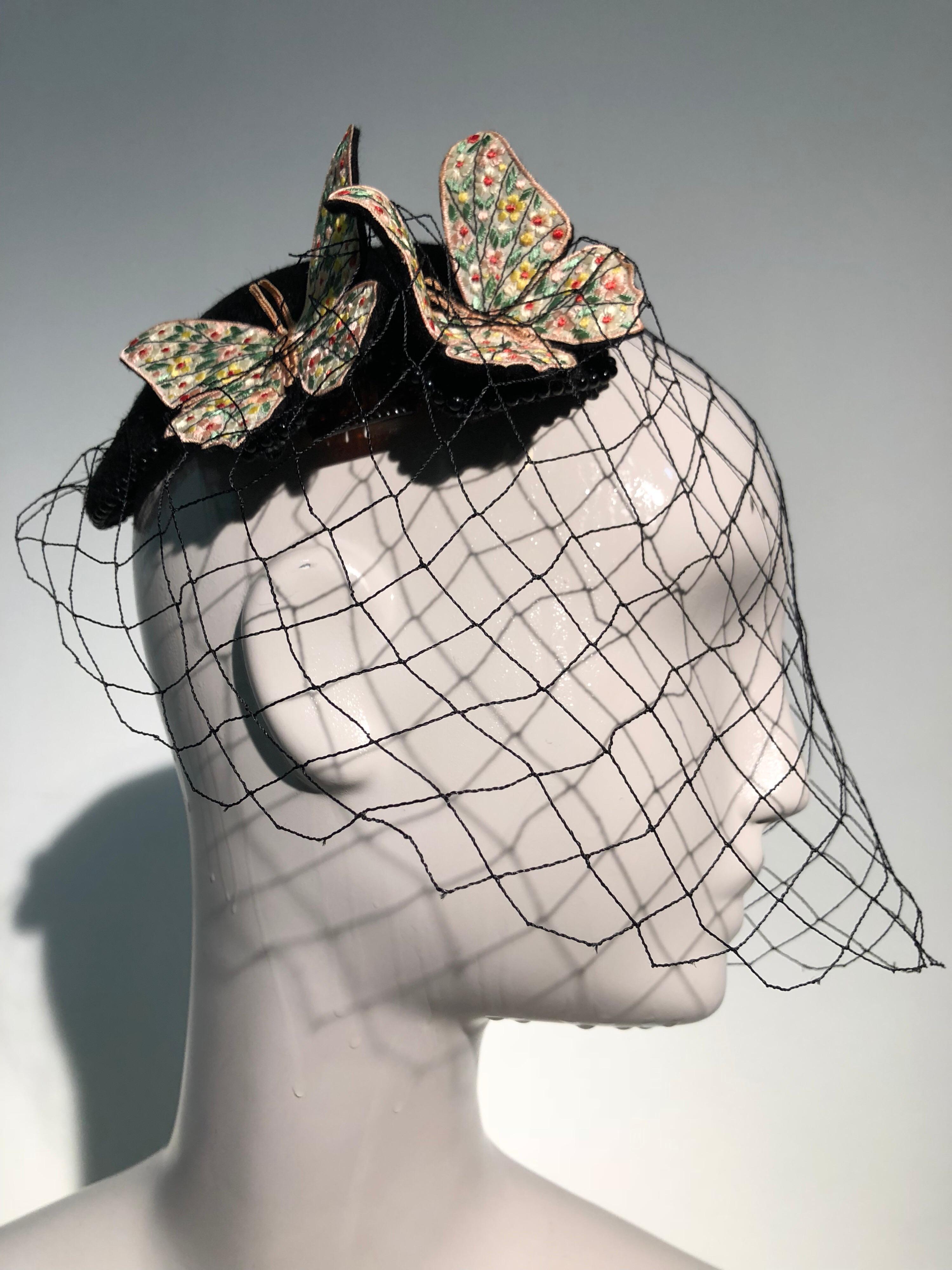 A wonderful 1966 Bes-Ben black felt cap with black bead trim at edge, colorful floral embroidered butterflies perched on top and an open net veil. A little drama perhaps?