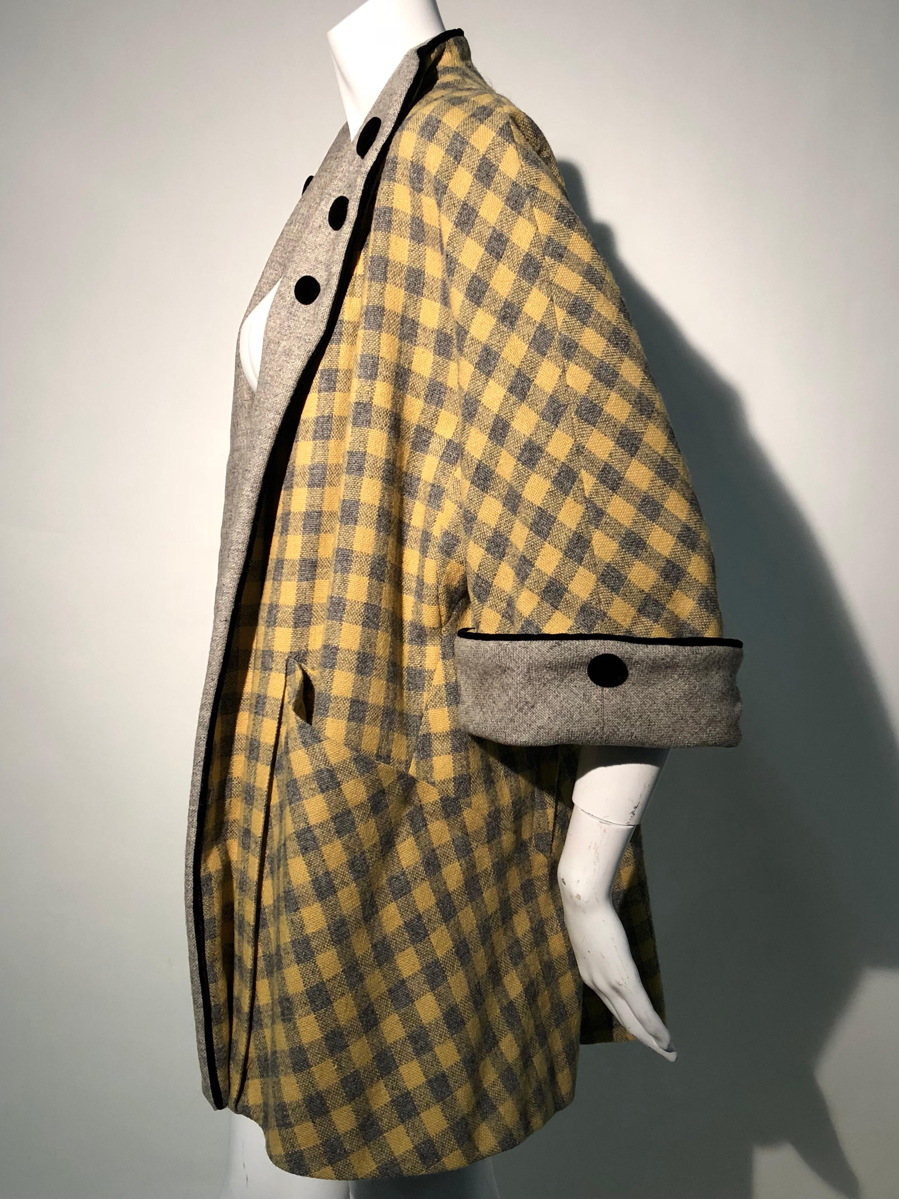 A really lovely 1950s Pierre Benoit couture quality, French stroller coat. A full swing cut, yellow and gray checked wool is partially cut on the bias with generous contrasting gray cuffs and collar that are embellished with velvet buttons and