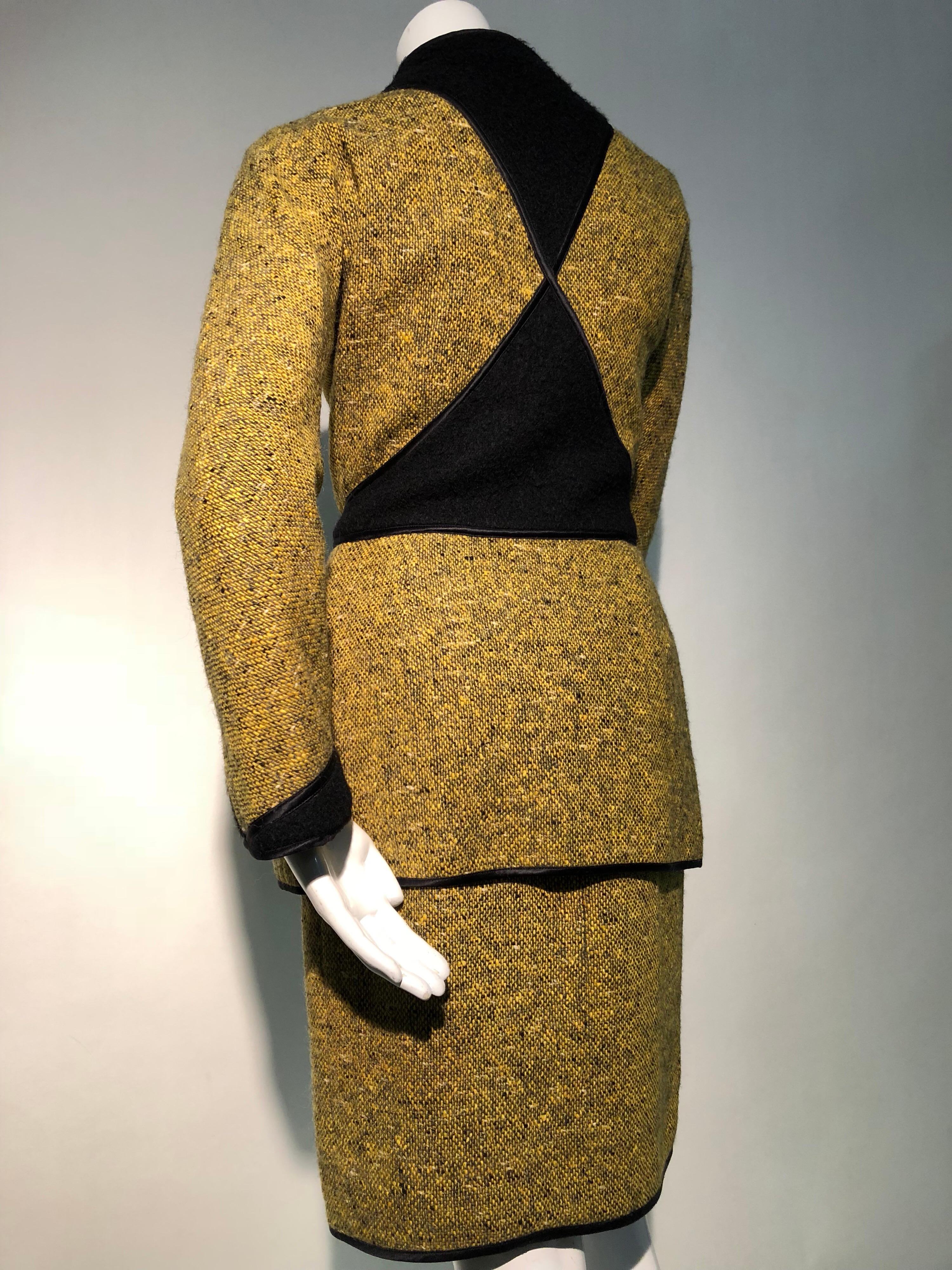 An exquisitely tailored, sleek 1990s Geoffrey Beene 2-piece ensemble in goldenrod and black tweed with geometric pieced panels of black wool and satin piping. The dress is a tweed skirt joined to a black wool blouse giving it the appearance of