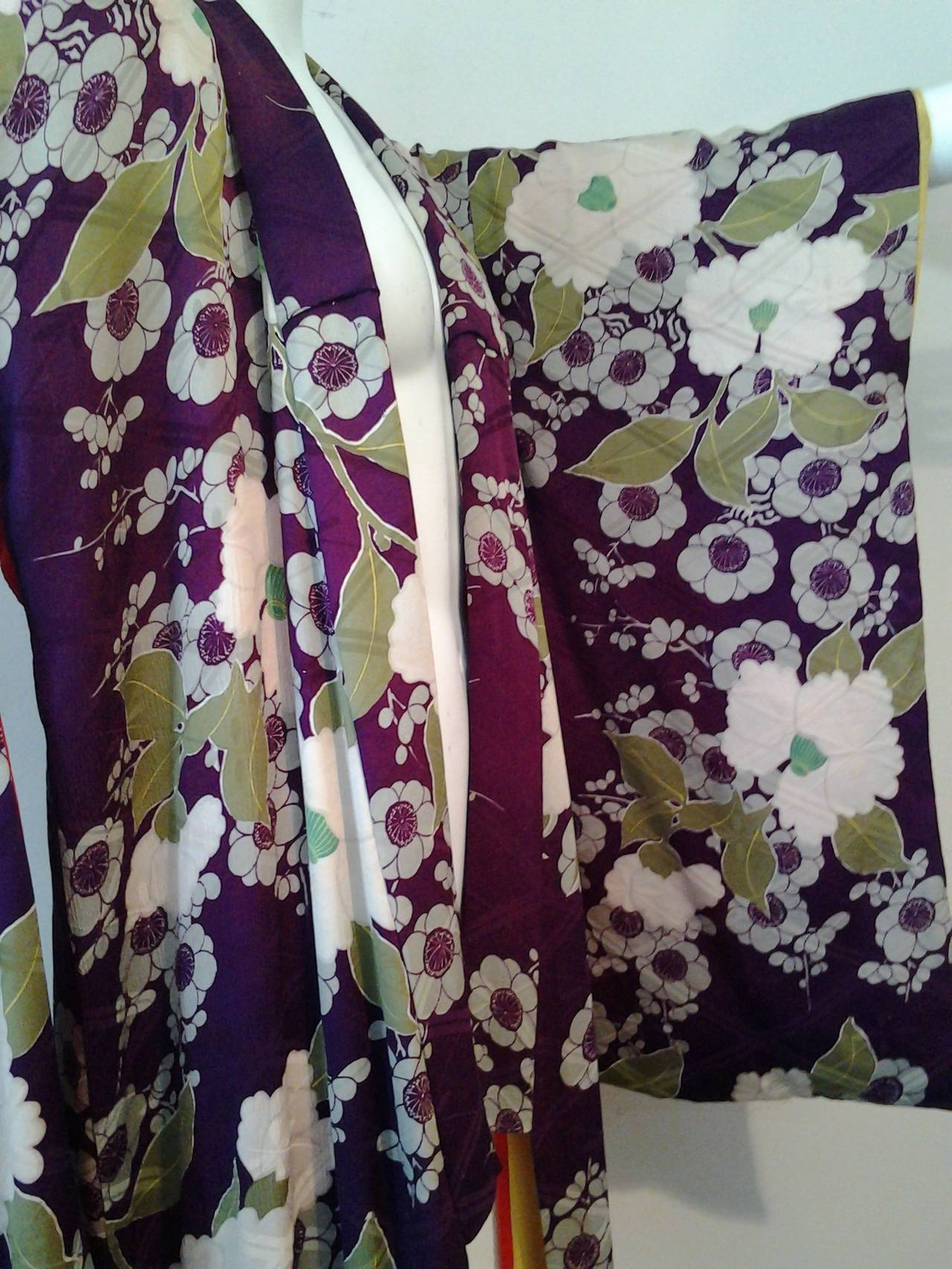 A beautiful 1930's floral print silk kimono in shades of plum and green with off- white.

Fully lined in red and yellow silk.

Beautiful soft silk and easy to wear.