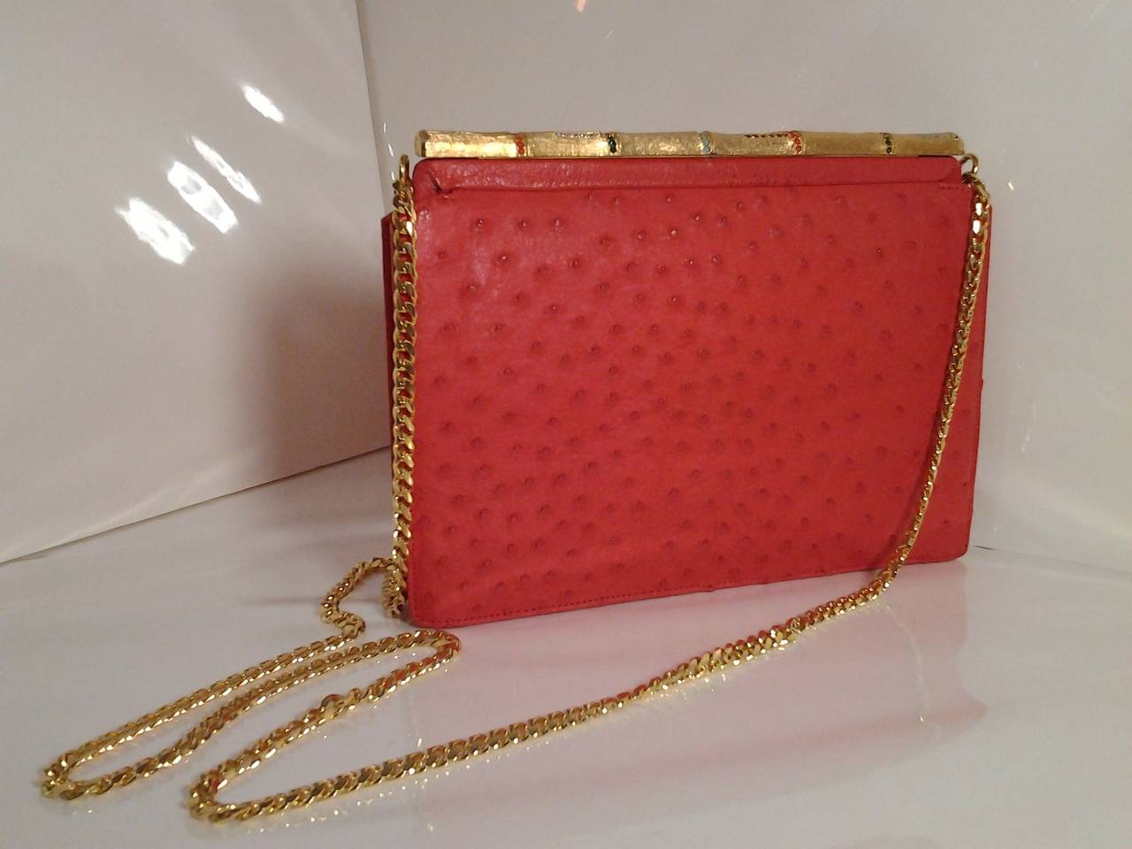 A gorgeous 1960s Koret shoulder bag:  Persimmon color genuine ostrich skin, shoulder length (not cross body) gold tone chain and wonderful gold-tone and jeweled faux bamboo clasp across top of bag.  Interior is in excellent condition with slide