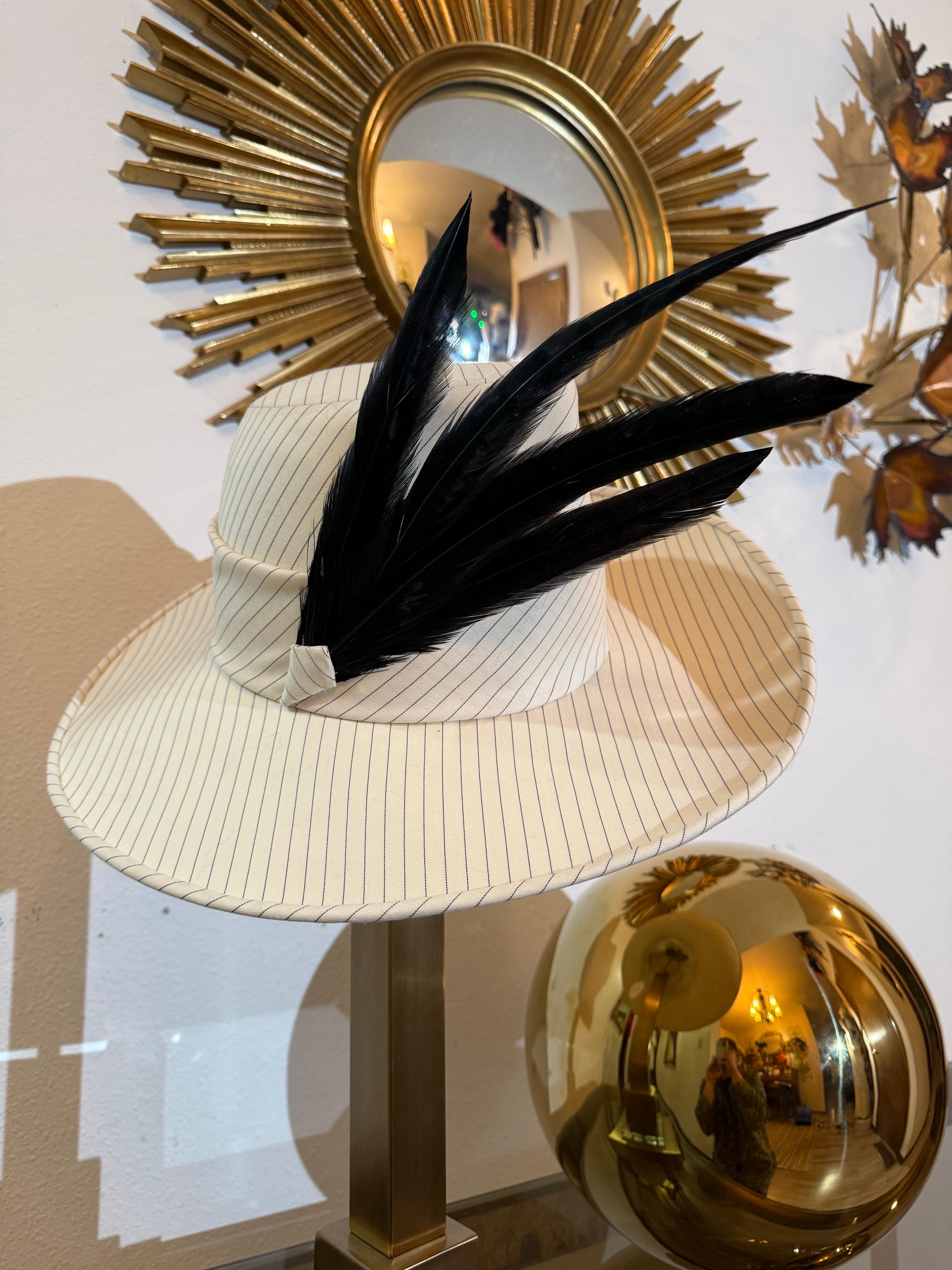 Fedora in gabardine di lana a righe nere e panna su misura di Maison Michel con pennacchi neri:  Un fedora a tesa larga, a corona alta e dal taglio sartoriale super intelligente, in un tessuto maschile di lana croccante.  Fascia in tessuto a righe a