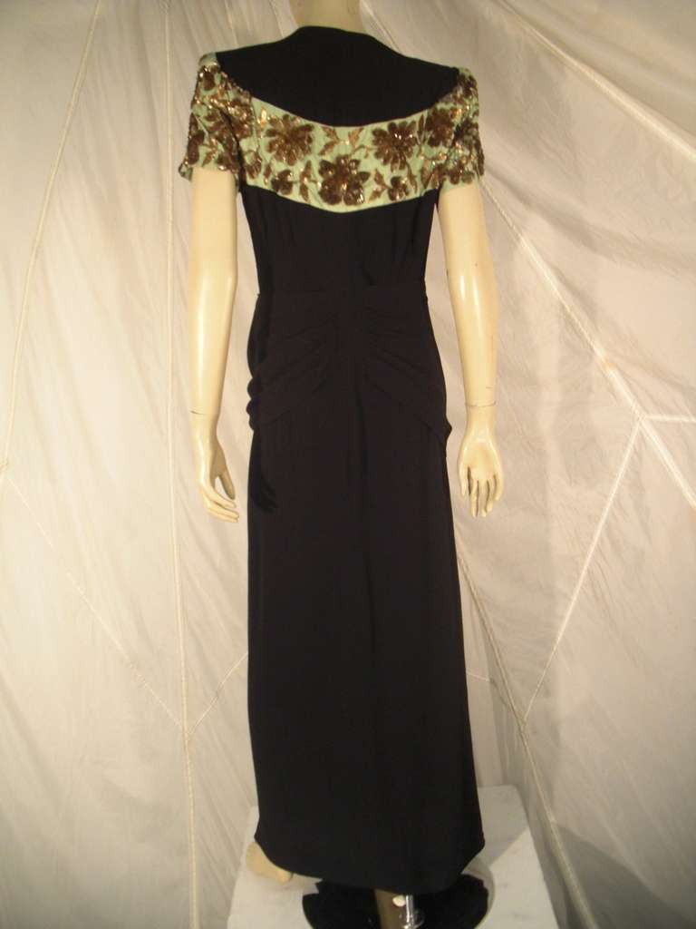 A sophisticated 1940s black rayon crepe gown by Rosine Paris, pleated, draped and swagged at the waist with a beautiful mint green taffeta contour panel at shoulders and back of bodice.  Lesage sequin embroidery.