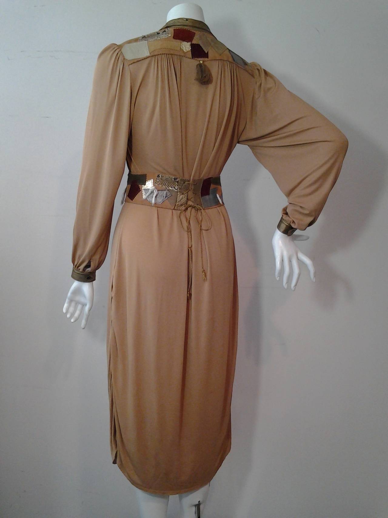 A 1970s terra cotta color matte jersey chemise style dress with suede, metallic leather and snakeskin patchwork shoulder yolk, collar, cuffs and wide coordinating belt with lace up back and front clasp lock.