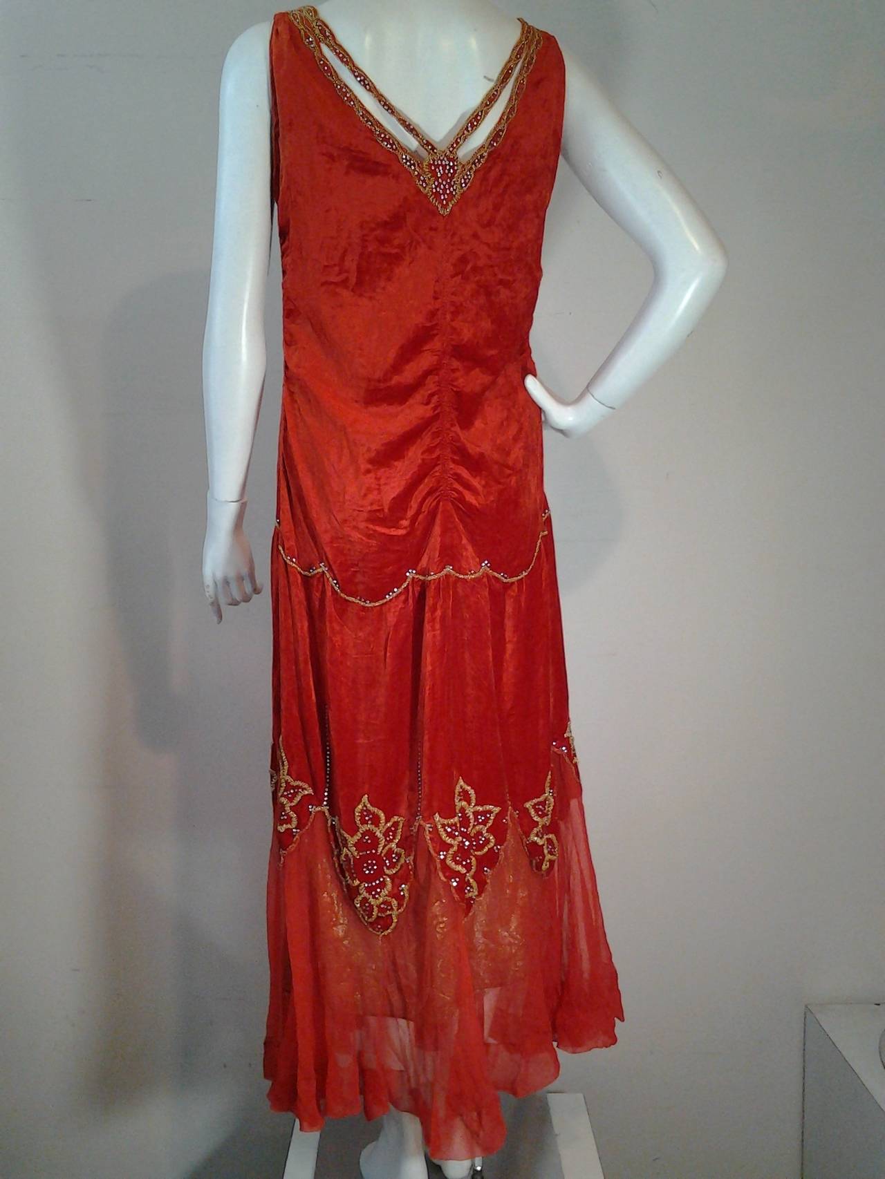 A stunning 1920s crimson panne velvet dropped-waist gown with lame lace underpanel, underslip, chiffon ruffled hemline, beaded florals and set rhinestones.  Neckline is a gorgeous butterfly with cut-out silhouette.  Absolutely beautiful!