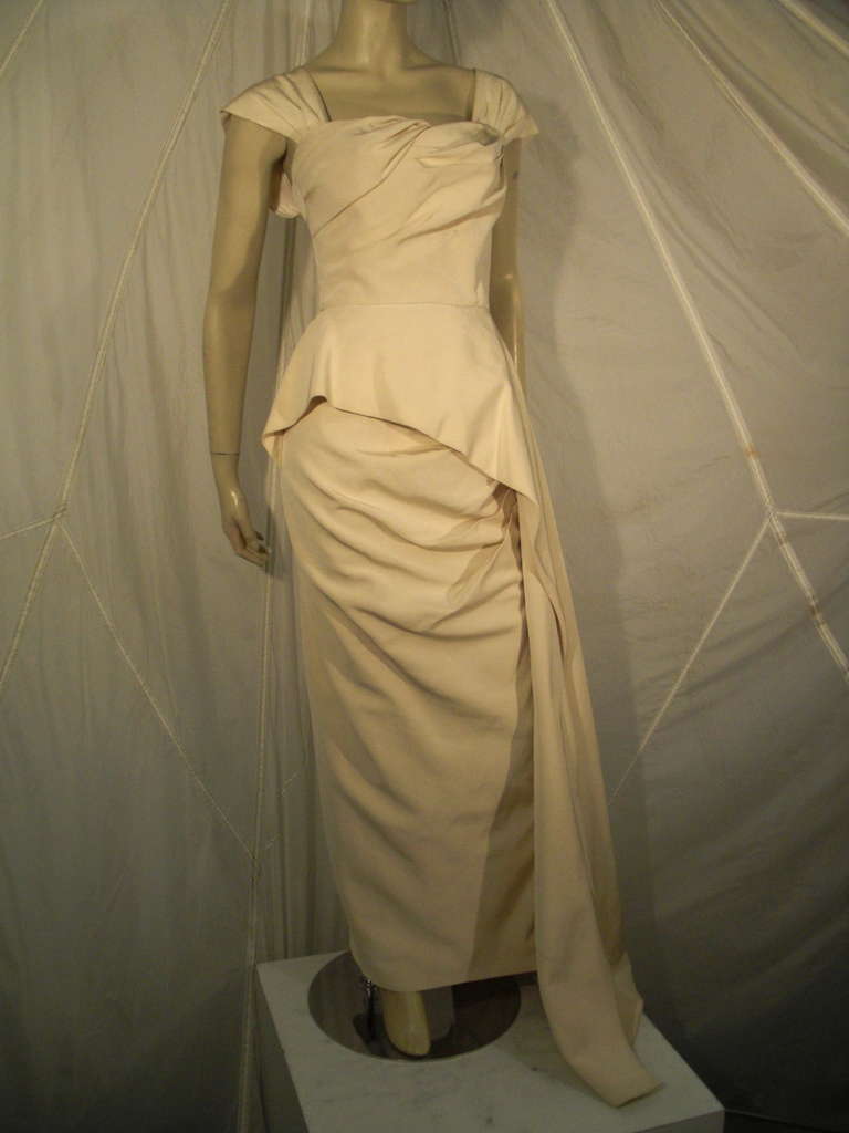 1950s couture, heavily-constructed silk faille gown with optional shoulder straps, boned bodice with asymmetrical draping at bust, flared peplum which cascades down one side to form train.  Completely hand-stitched and lined.  Gorgeous.