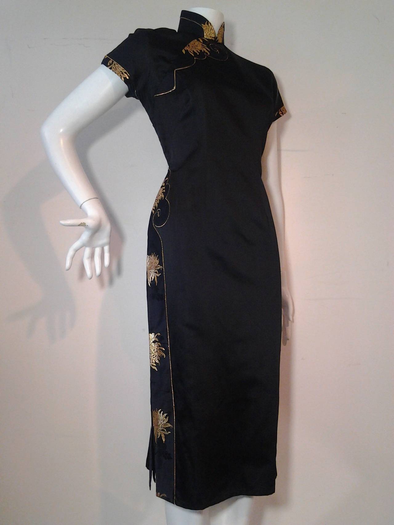 A gorgeous 1950s Hong Kong silk satin cheongsam with gold piping detail and chrysanthemum panels in gold brocade.  Side zipper and snaps at shoulder for easy on and off.