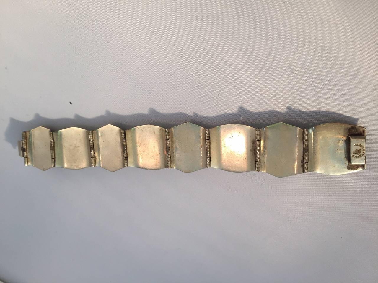 A fabulous 1940s sterling bracelet from Mexico with jadeite stones (some carved into faces with movable earrings )  Slide-in clasp.