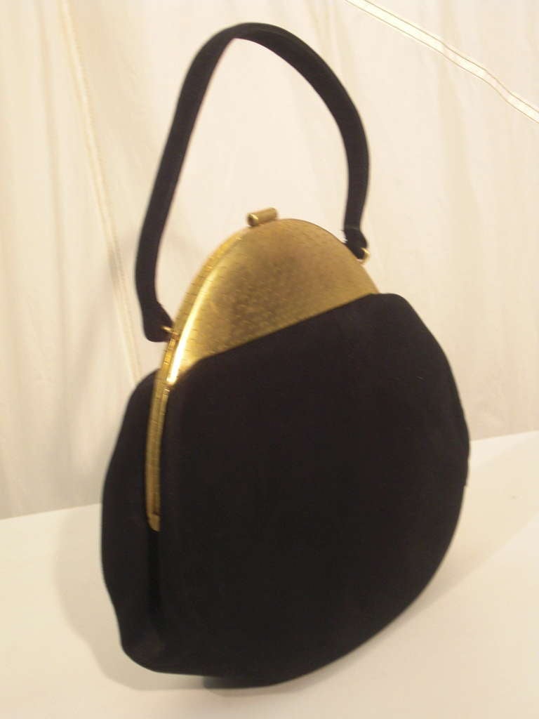 A fabulous late 1940s Koret black kid suede handbag with a uniquely streamlined metal top and clasp area, chain connected coin purse inside as well as gold piped slide pockets.