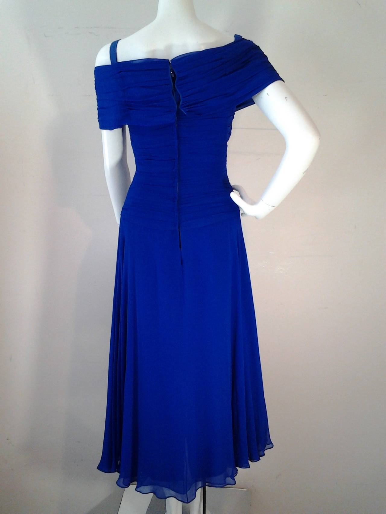 A wonderfully vibrant cobalt blue 1980s Arnold Scaasi silk chiffon gown with lots of ruched fabric in the flowing skirt and a structured 