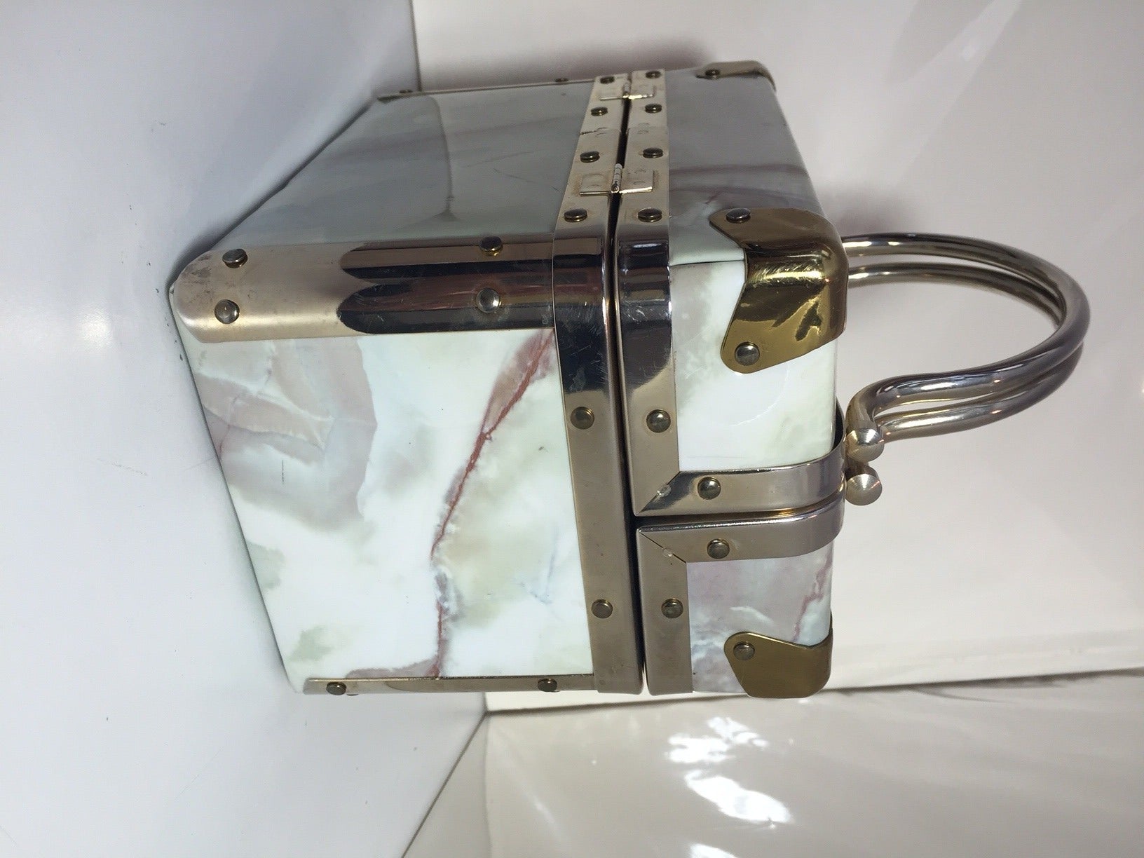 A great 1960s marbleized white vinyl covered top-opening box bag with chrome and rivet edges, corners, feet and handles.  Tan fabric interior.