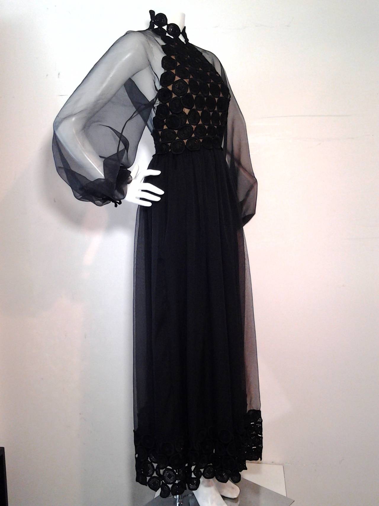 A fantastic early 1970s Werle of Beverly Hills black chiffon and circular lace hostess gown:  Lace bodice is lined and cut in a halter line.  Voluminous chiffon sleeves and back as well as overskirt edged in the same circular lace.