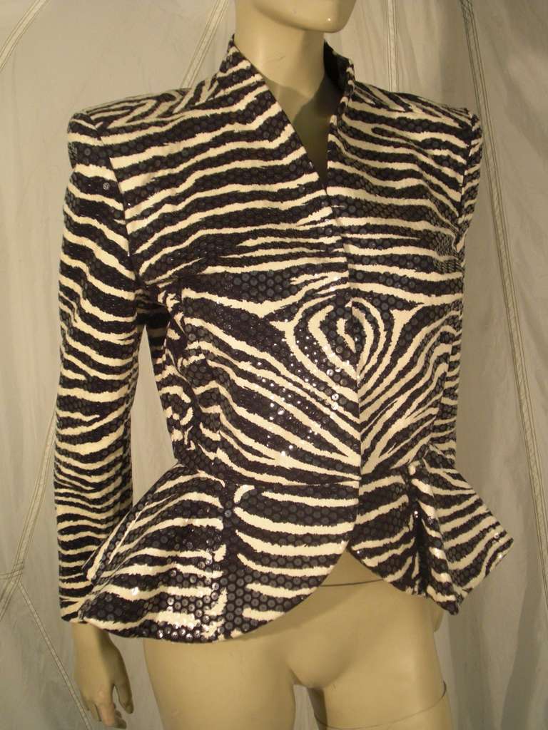 A fantastic 1980s Travilla evening jacket:  sequin glazed zebra print with hook and eye closures, strong shoulder silhouette and flared peplum.  Silk satin lined.