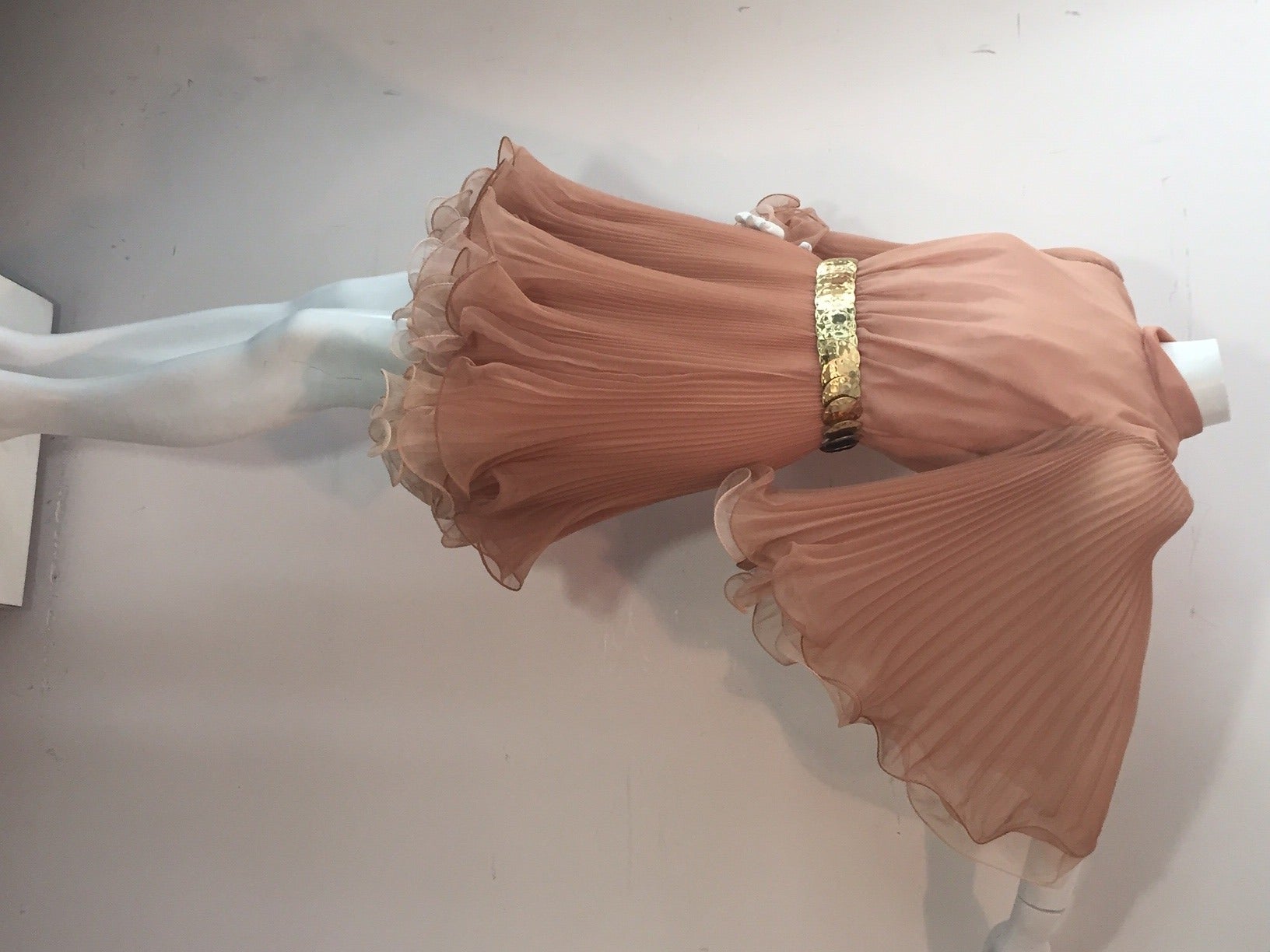 A super cute 1960s Miss Elliette taupe and beige organza mock-turtleneck mini dress with double-layered construction, pleated and ruffled angel wing sleeves and skirt.  Included is a gold-tone adjustable metal disc belt.  Back zipper.