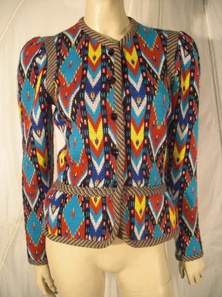 A fabulous Yves Saint Laurent wool knit jacket in an Ikat pattern with banded striped edging, peplum and shoulder emphasis. Buttons down front. Missing tag.