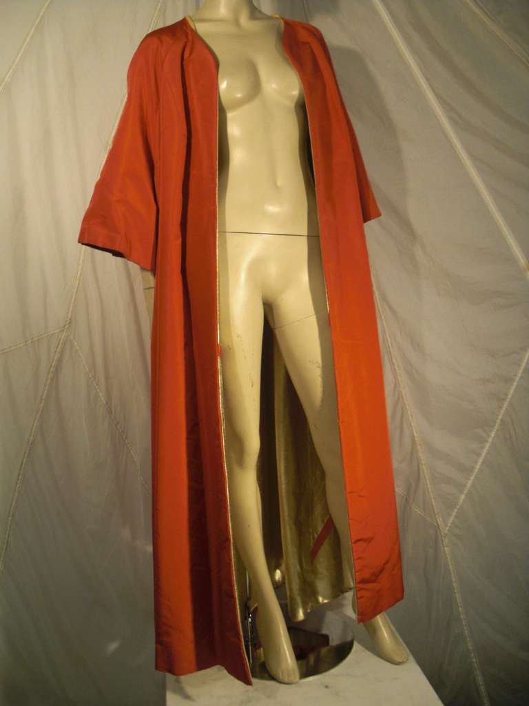 A dramatic gold lame and burnt orange reversible opera coat with 3/4 length sleeves.