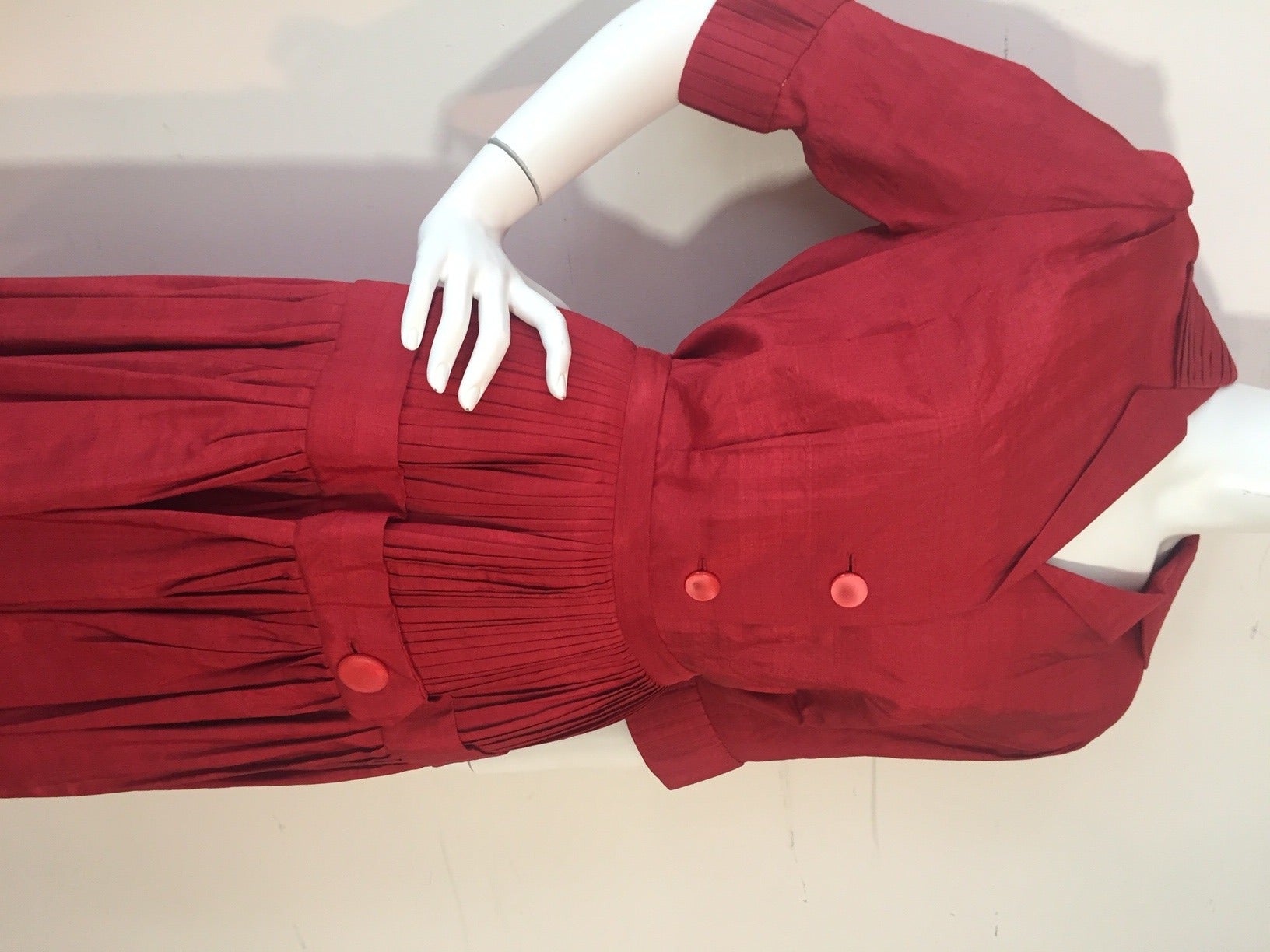 A gorgeous 1950s casual 2-piece cinnabar /red silk skirt and blouse set:  Button-down front with darts and 3/4 length sleeves.  Cuffs of blouse are pleated like skirt.  Skirt is full and heavily pleated with a button embellished band at hip.  Skirt