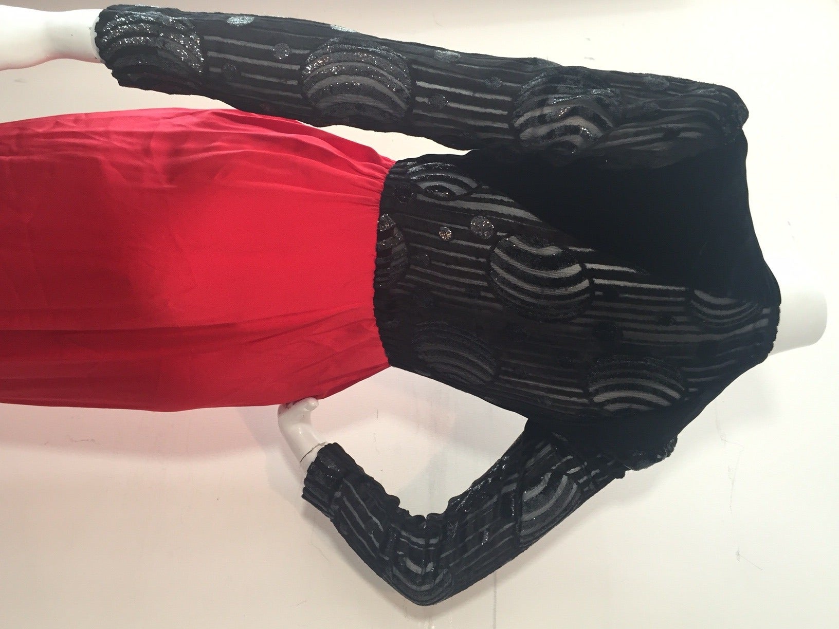 A sexy 1980s siren gown:  Red pleated silk satin wrap skirt, black burnt-out velvet bodice with long sheer sleeves and shoulder structure.