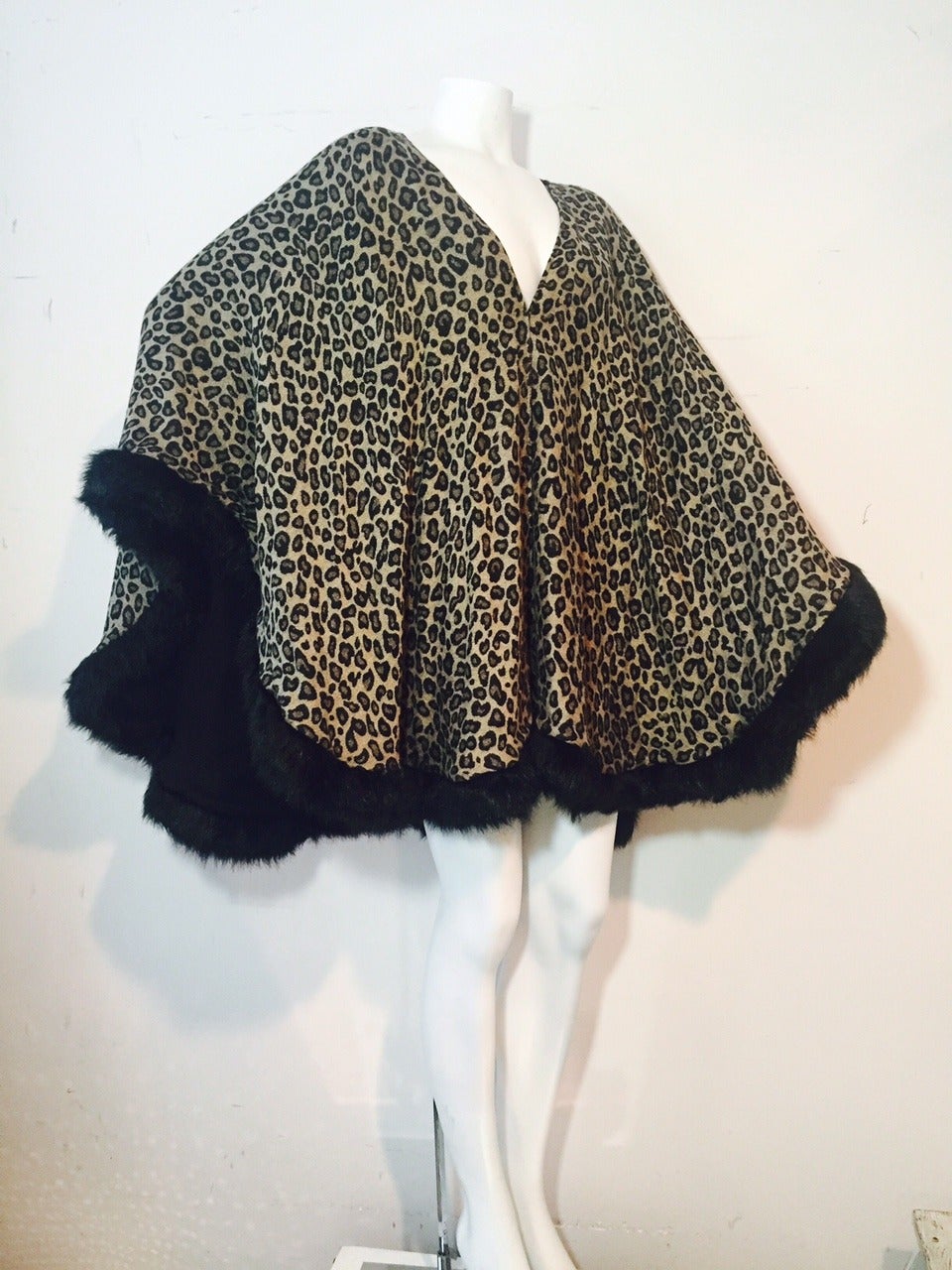 A dramatic 1980s I. Magnin leopard print wool challis wrap, lined with black wool challis.  Edged in black faux fur trim.
