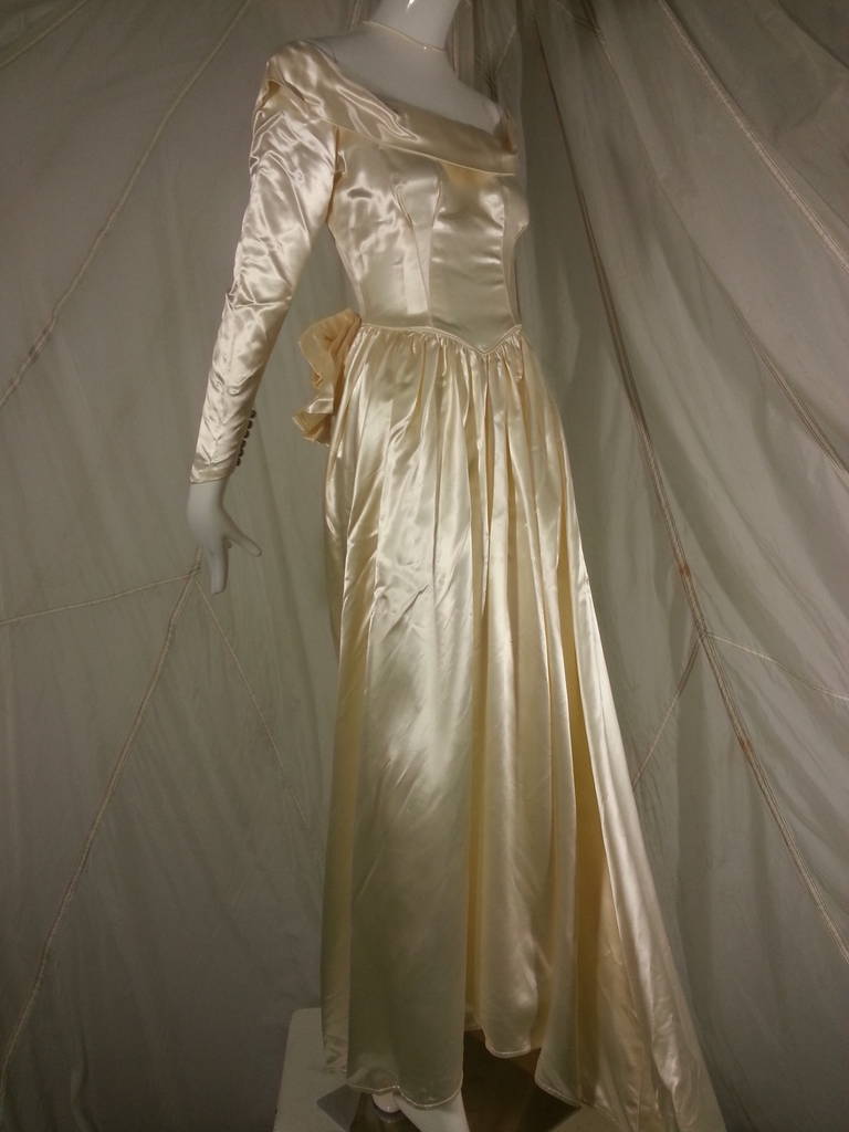 1949 Adeline Creme Satin Wedding Gown for City of Paris 
In mint condition.  Heavy satin in buttery cream silk satin.
Very very little wear.  Highly unusual for a dress like this.
From the famous City of Paris Department Store in San Francisco.