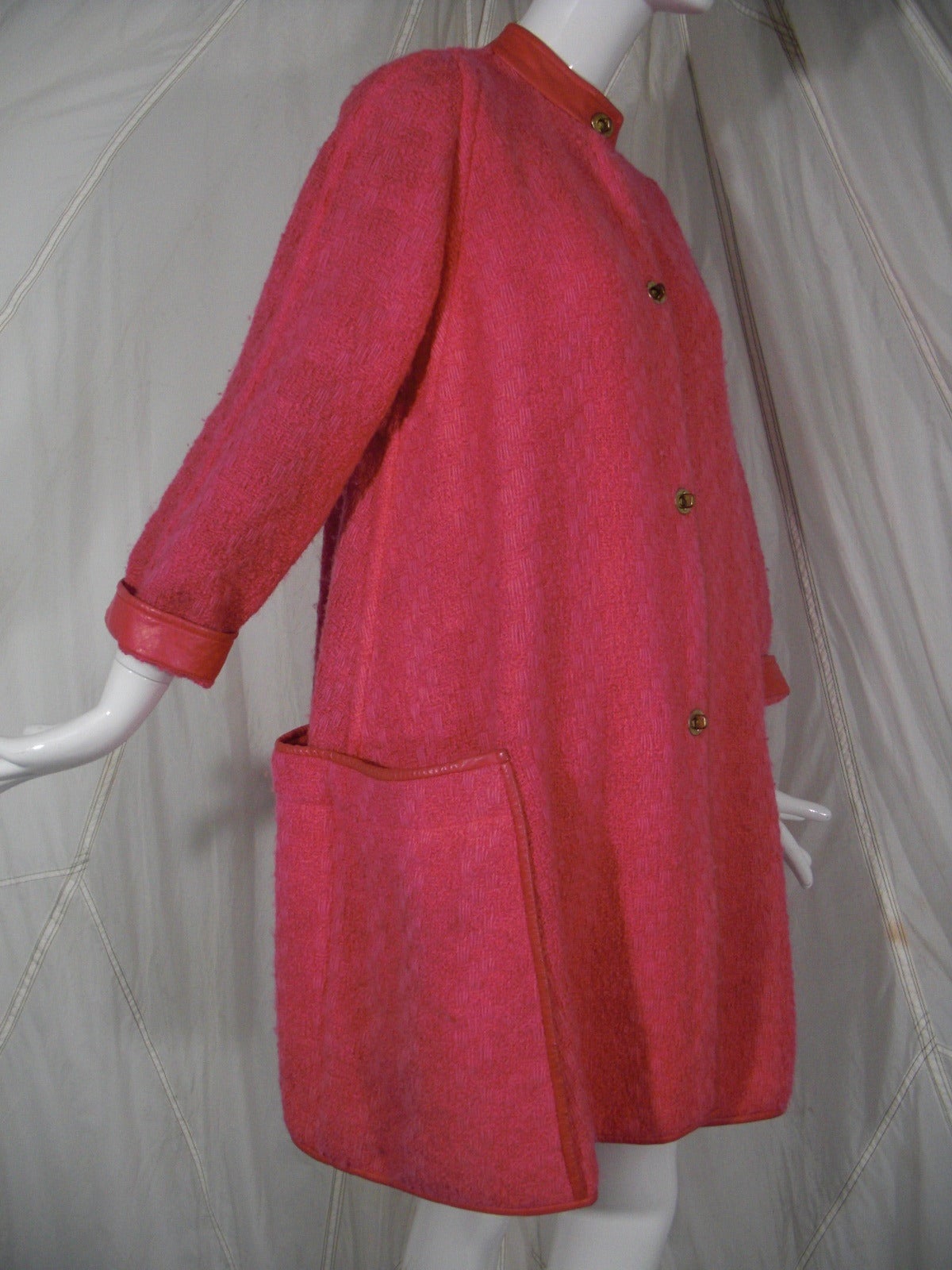 A vibrant 1960s Bonnie Cashin lipstick pink wool tweed coat with leather trim at pockets, neck and edges.  Trademark Cashin metal toggle closures. Unlined.