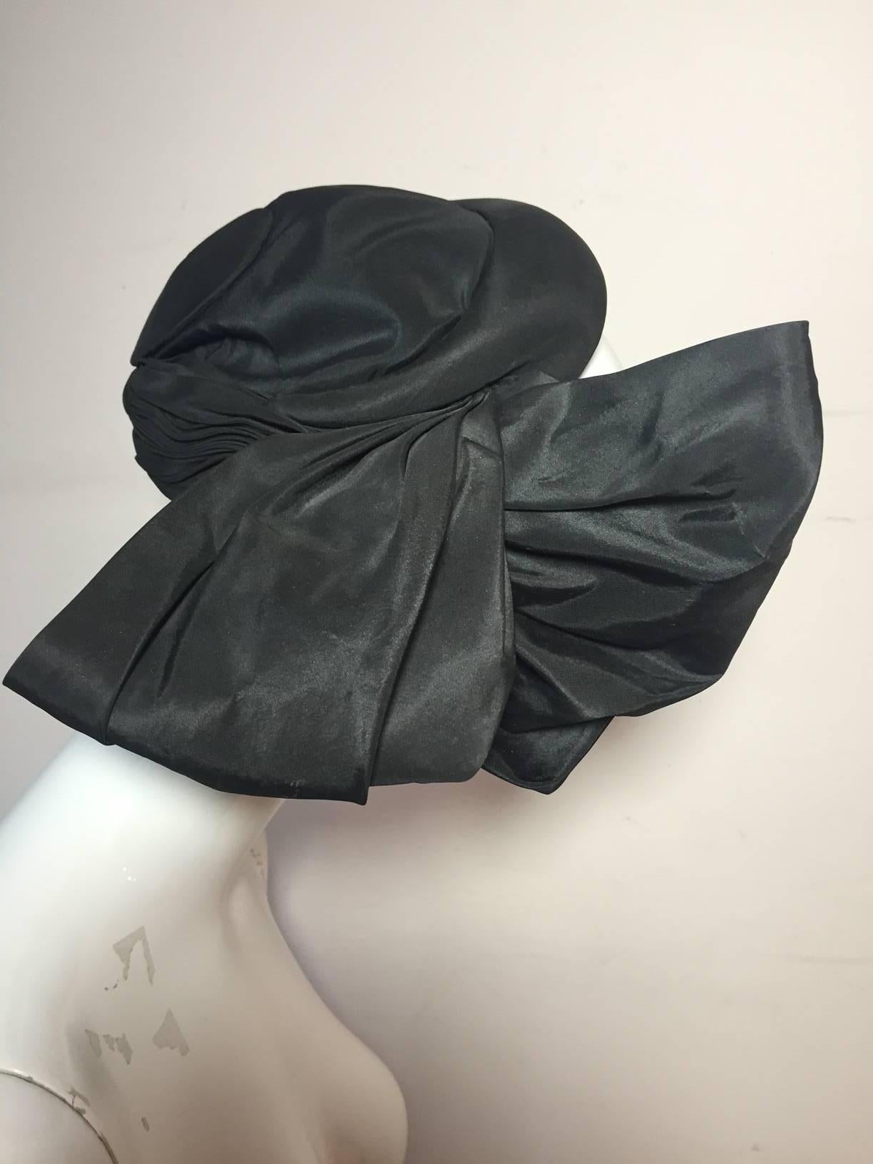 A divine 1950s Lilly Dache couture silk taffeta cocktail hat: Structured buckram spiral design with voluminous pleated and twisted taffeta bow at side.  Lined in a light wool jersey and complete with wired tabs for secure fit. 