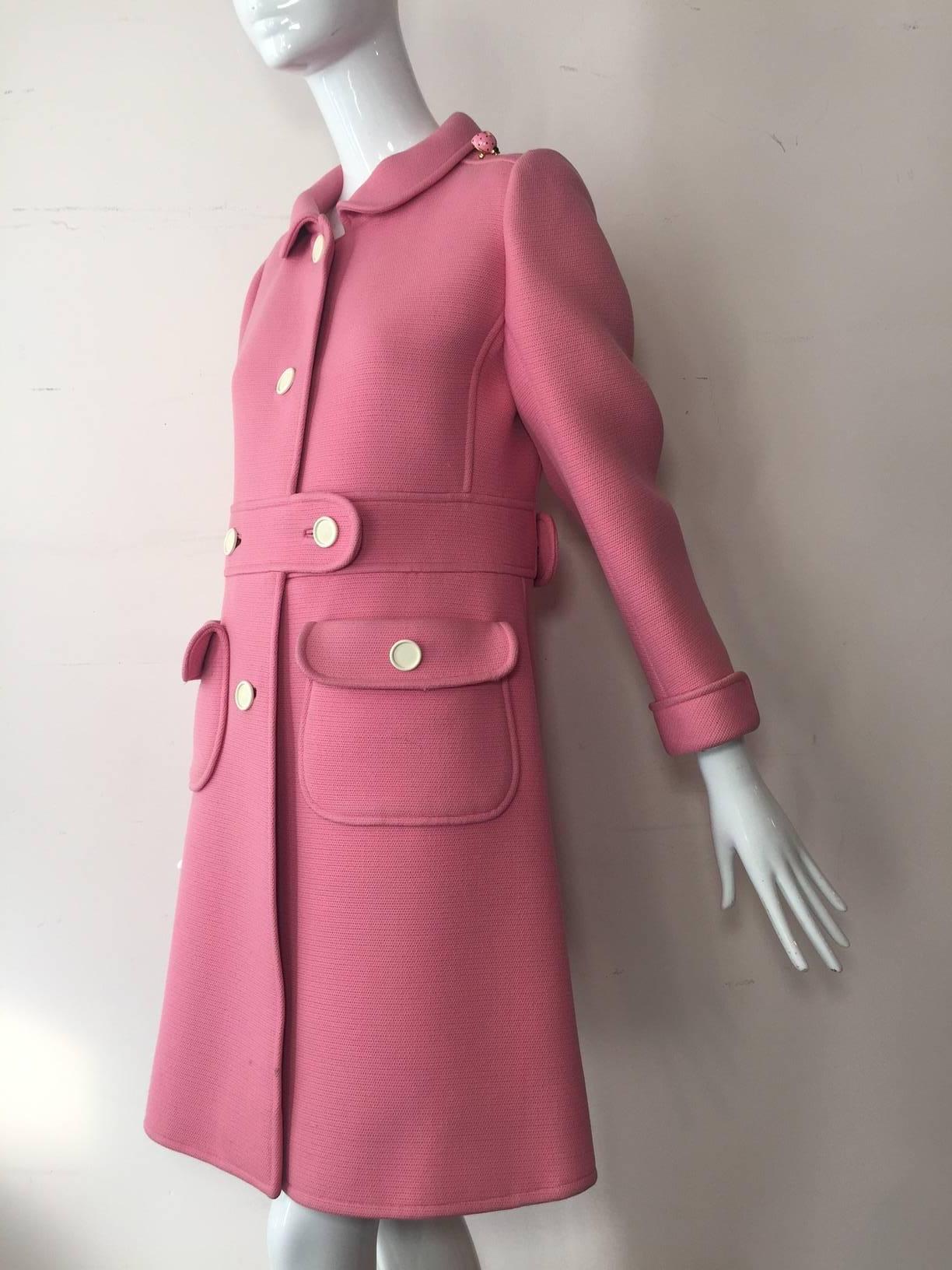 A fabulous 1960s Courreges pink wool, Mod styled coat with Peter Pan collar, military-inspired design and white buttons.  Fully lined with back belt and flap pockets. 