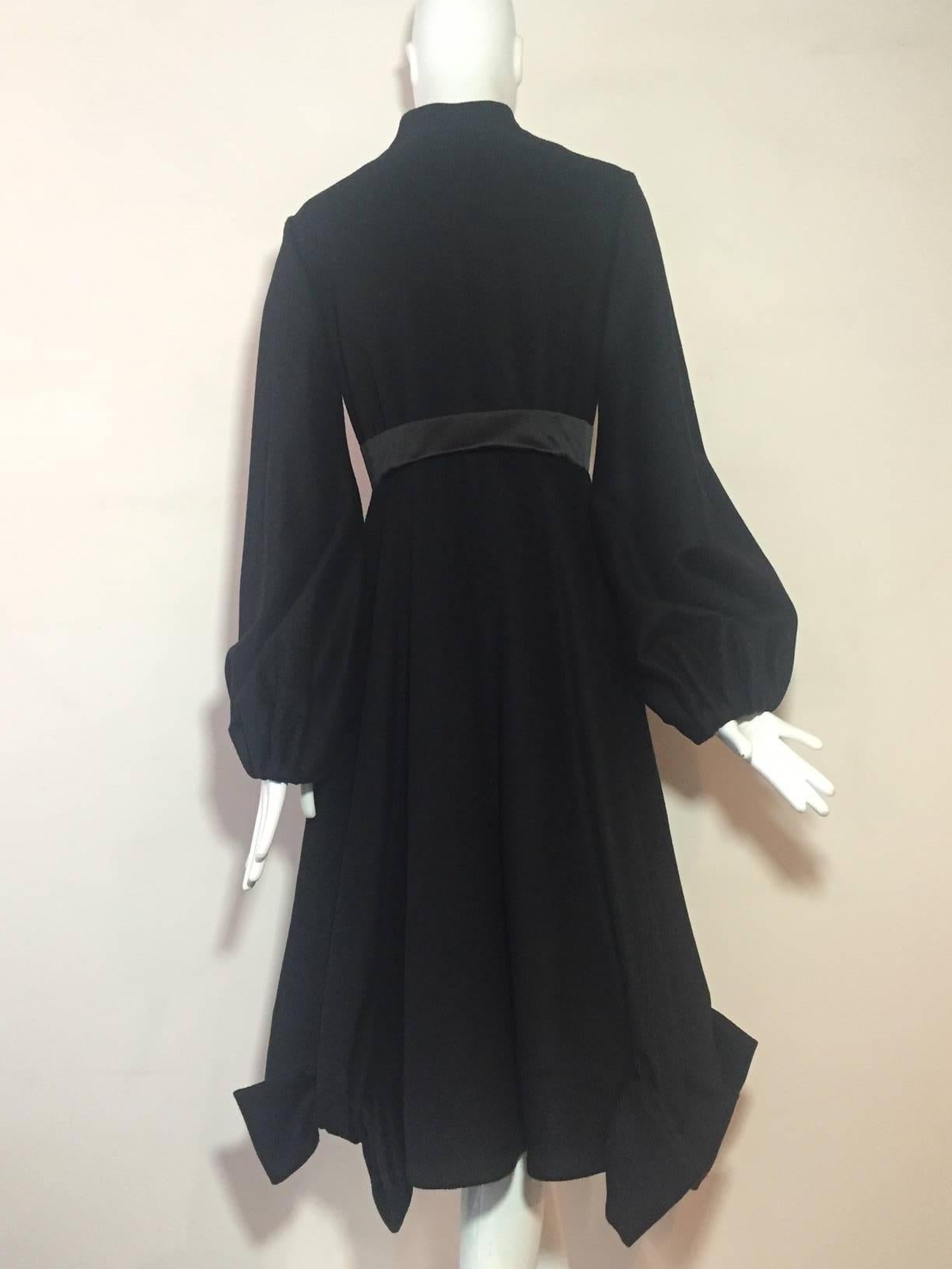 A beautiful Givenchy black wool and cashmere Princess style coat:  Banded neck with hidden snap closures. Silk satin empire waistband. Balloon tucked snap-closure sleeves.  Full skirt with interesting sculpted bow detail at hem.  Rayon floral satin