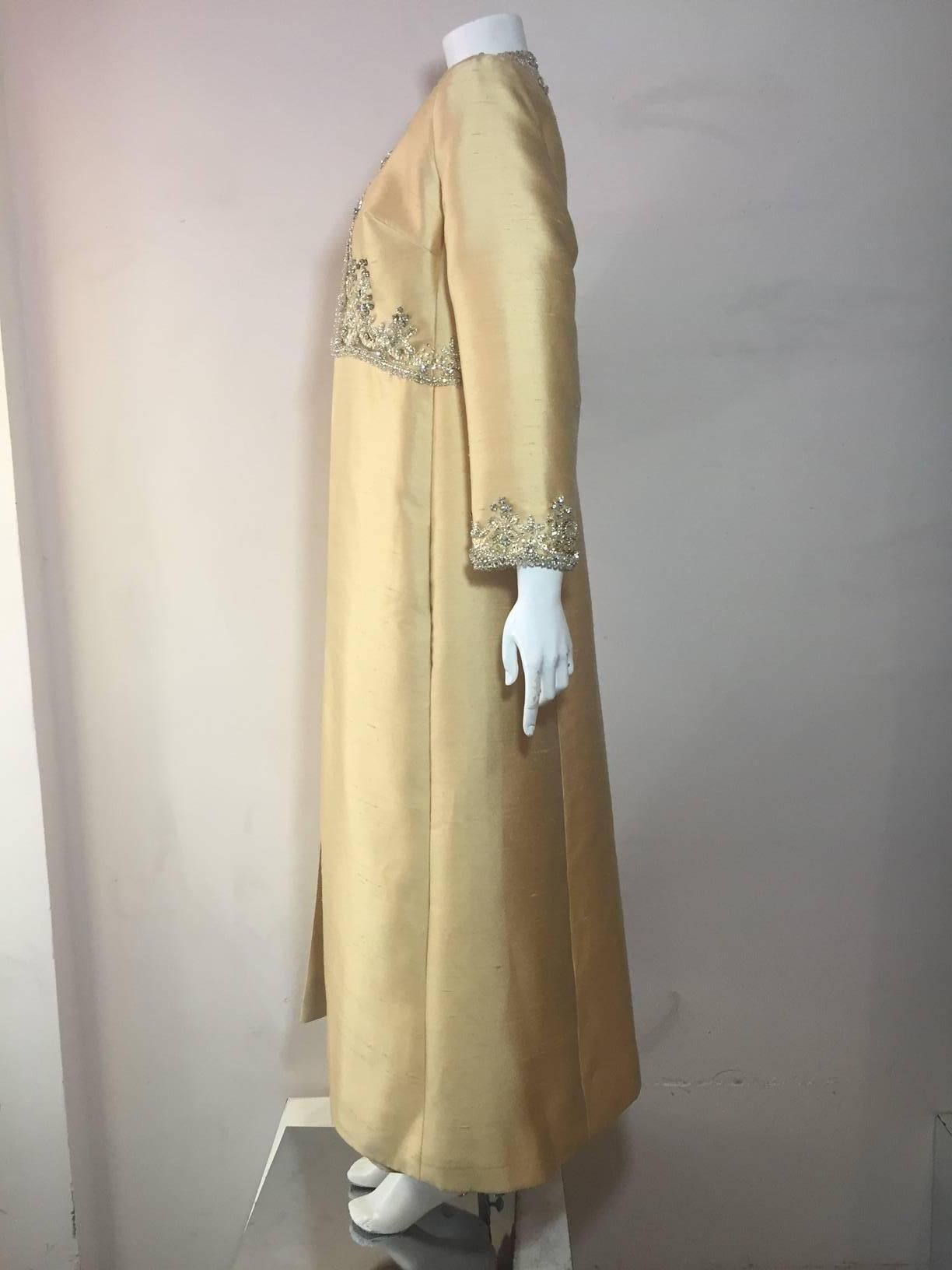 A heavenly 1960s champagne shantung 2-piece custom made ensemble:  Gown is Empire waist and sleeveless with heavily encrusted sequin, rhinestone and faux pearl embellishments running entire length of front.  Coat is constructed to fit over gown with