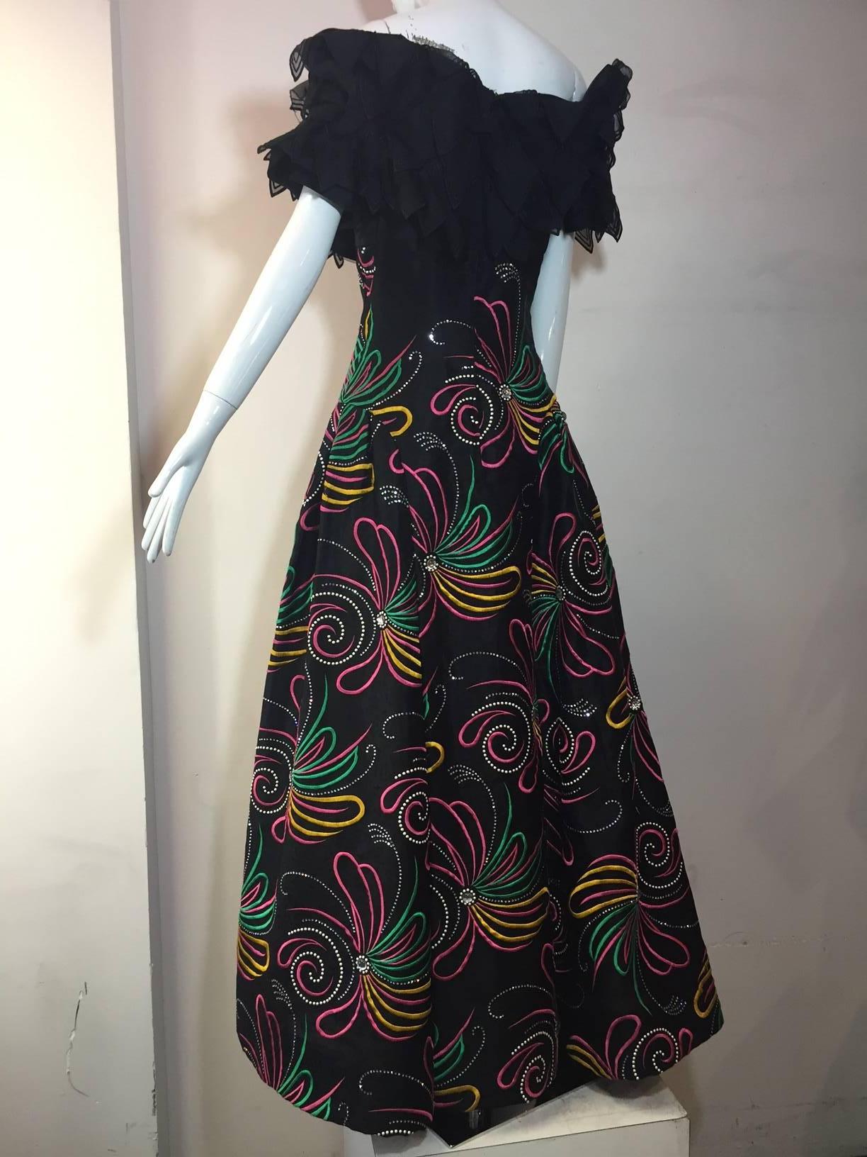 A 1980s Arnold Scaasi off-the-shoulder ball gown;  Skirt is full with pleating at side of hips.  Pink, yellow and green swirls with rhinestone and faux pearl sprays and a cabochon center stone on silk jacquard.  Stiffened horsehair hem.  Fully boned