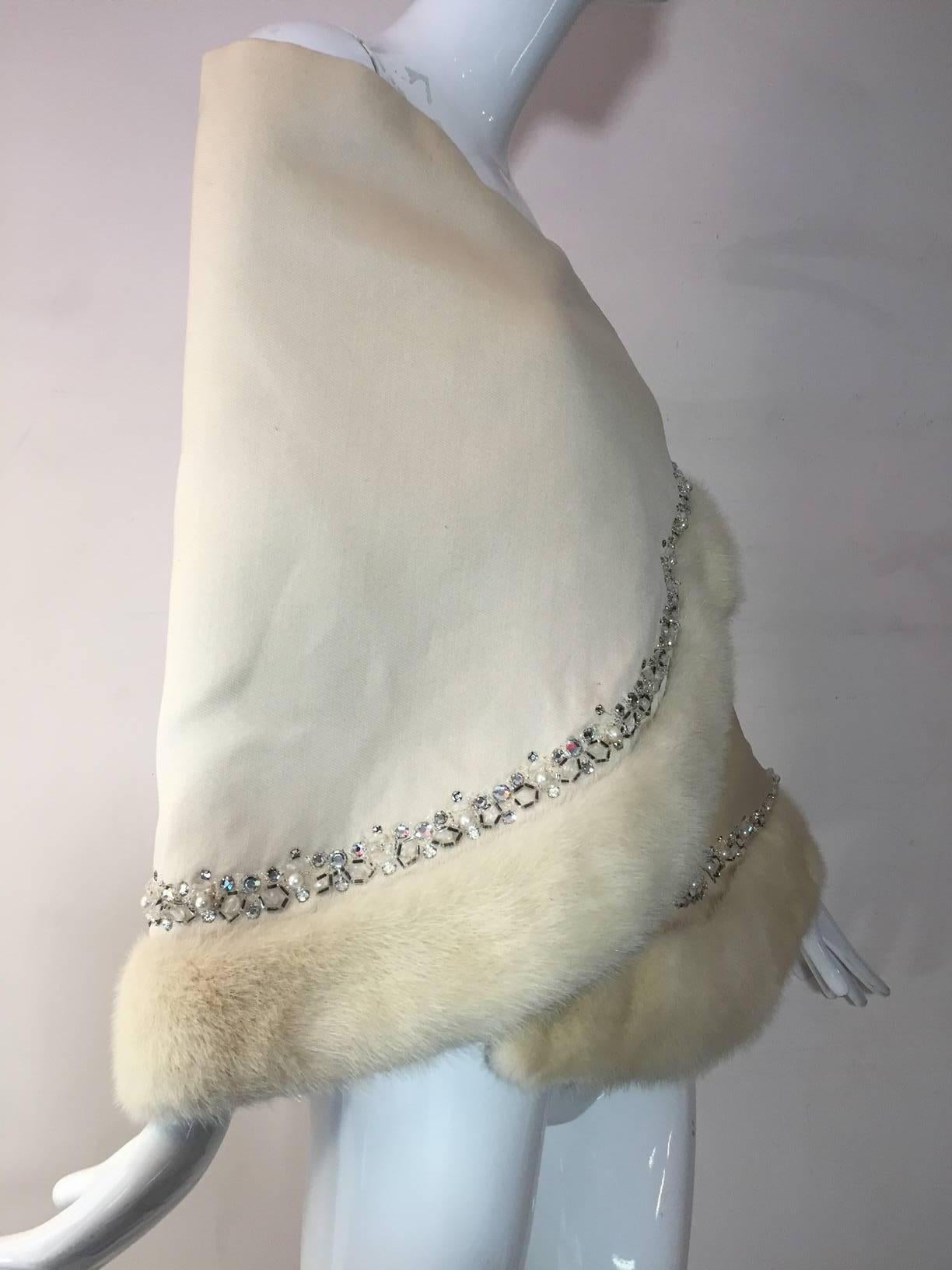 A gorgeous 1950s winter white silk faille asymmetrical wrap w/ white mink and rhinestone trim at bottom edge.  Snap closures.  