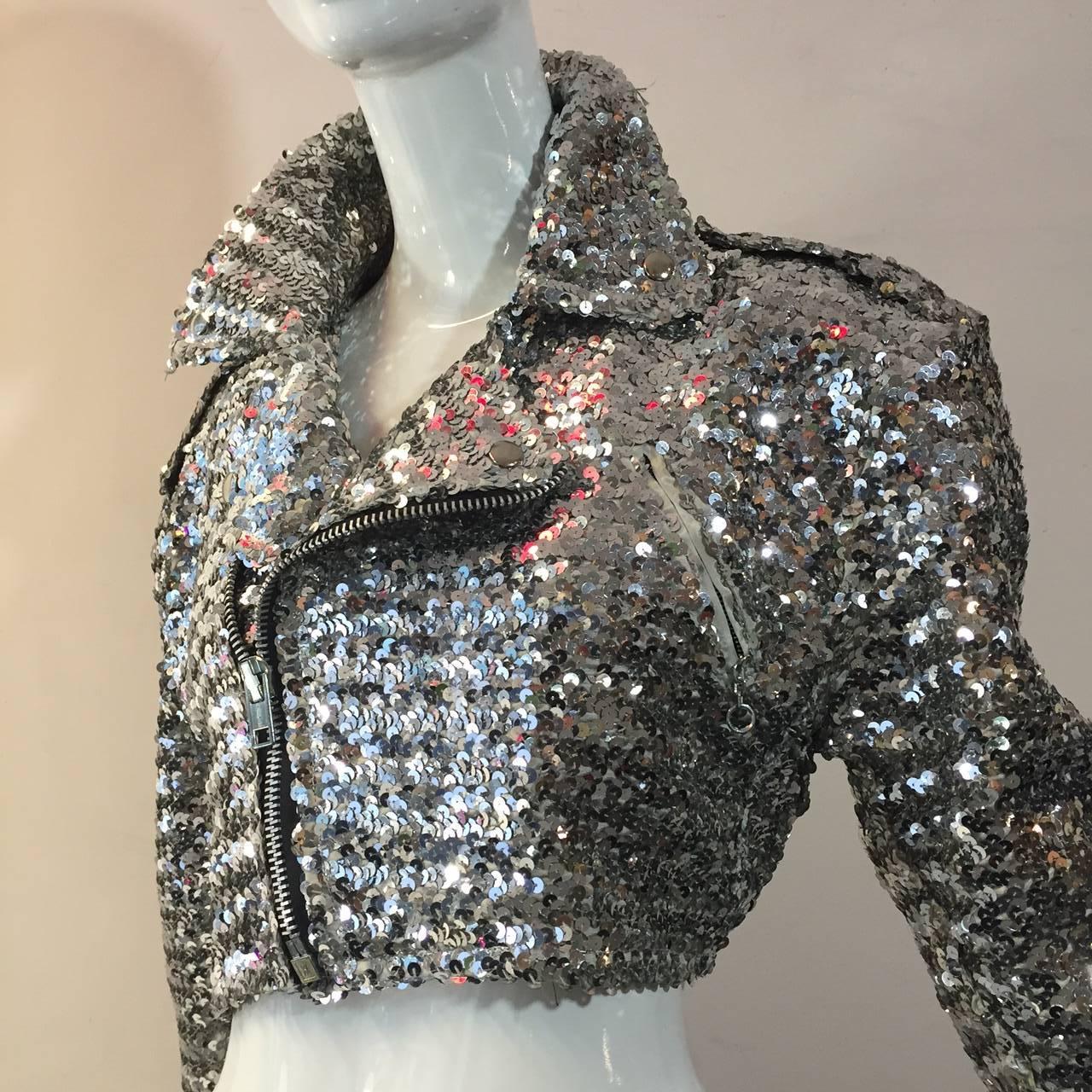 Eine witzige:: mit silbernen Pailletten besetzte:: klassische Jacke im Motorradstil der 1980er Jahre mit Reißverschluss vorne und an den Ärmeln. Inklusive Gürtel.