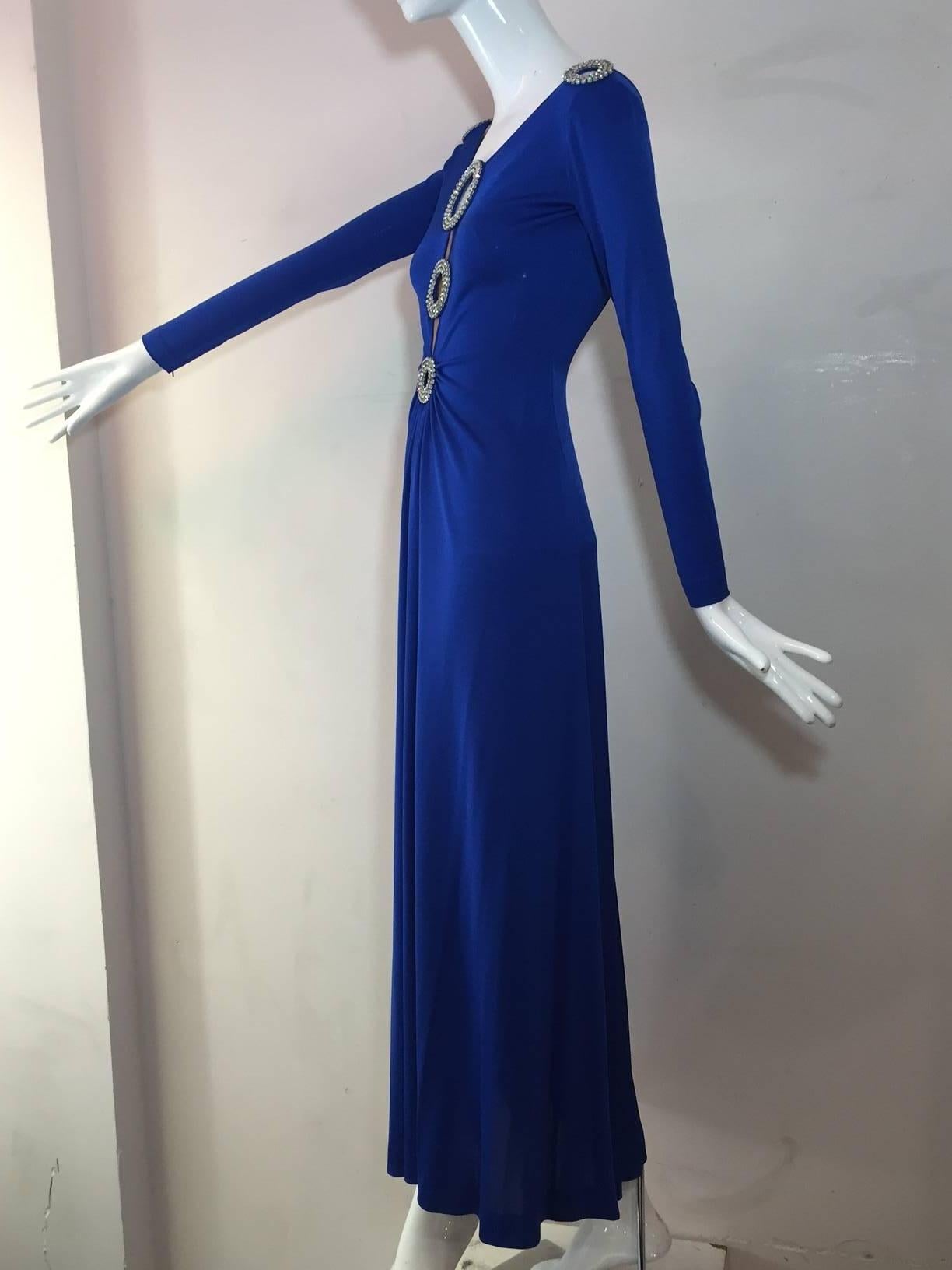 This 1970s Loris Azzaro cobalt silk jersey gown with low scoop back and spectacular rhinestone ring peek-a-boo details.  Front-gathered skirt and long zippered sleeves for streamlined fit. 