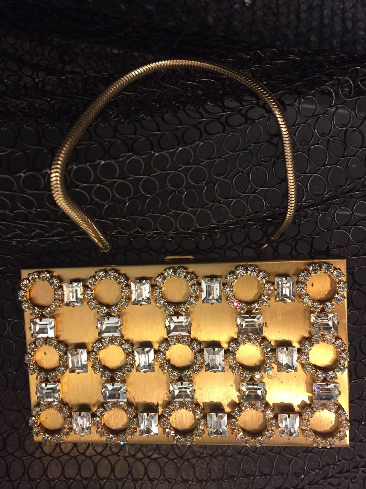 A gorgesou 1950s gold-tone rhinestone encrusted evening compact clutch with chain handle.  Small thin compartment for credit card and key.  Empty lipstick compartment. and 