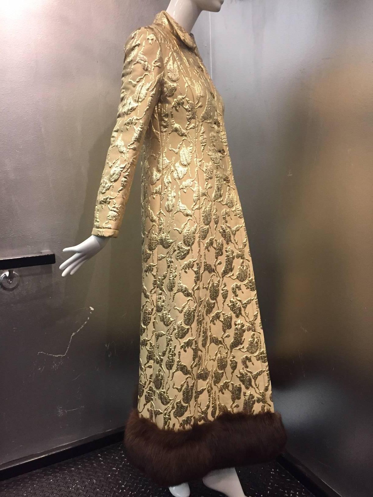A fantastic 1960s Saks Fifth Avenue gold lame matelasse evening coat:  Princess cut seaming, jeweled buttons at front, back center, and cuffs. Tuxedo shirt-style collar.  Fully lined in tissue silk and hemmed with lush sable-toned fox.