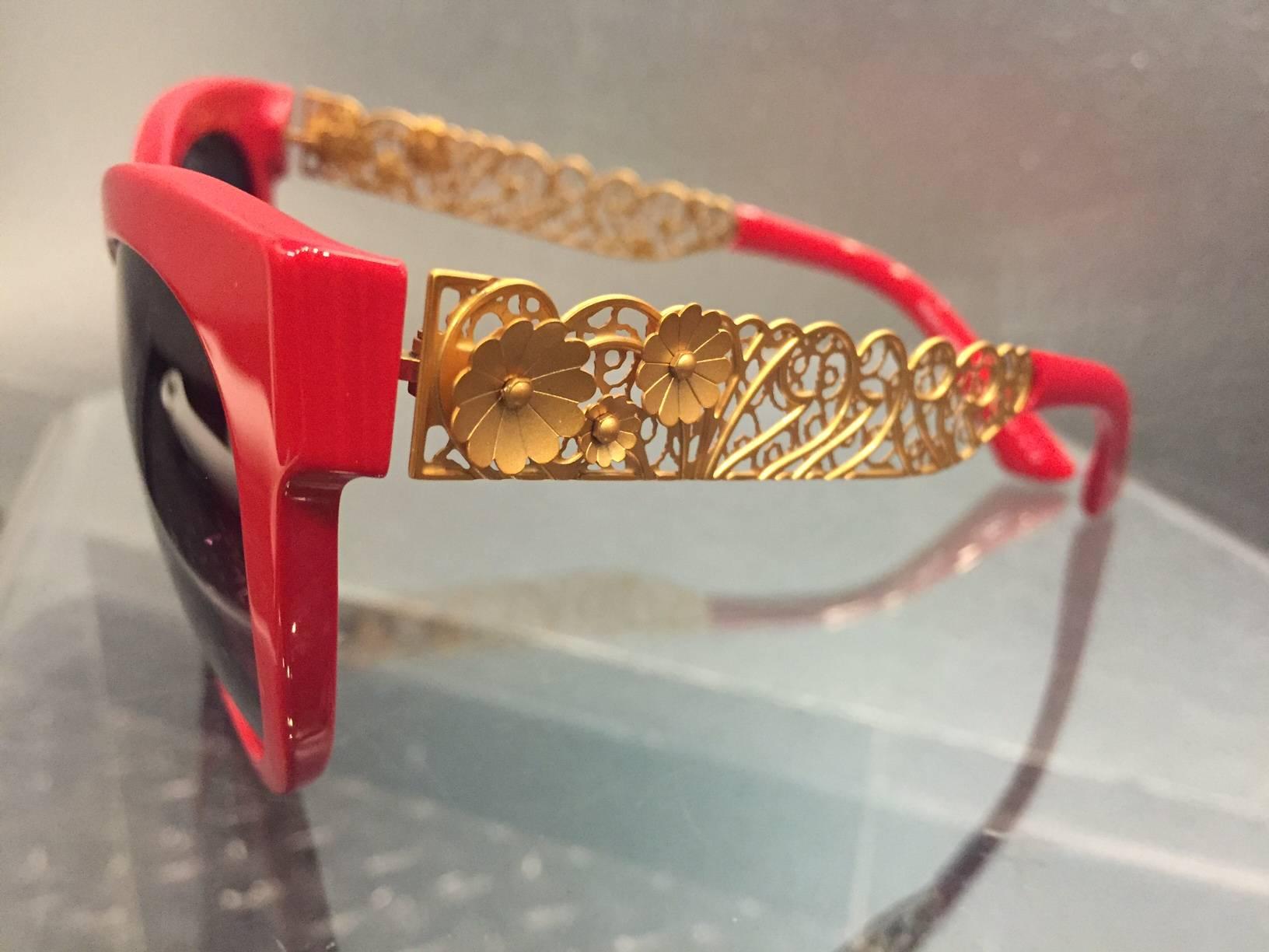 A fabulous 1980s pair of cherry red resin Dolce & Gabbana sunglasses :  The perfect cat eye shape with gold-tone floral filigree arms.  