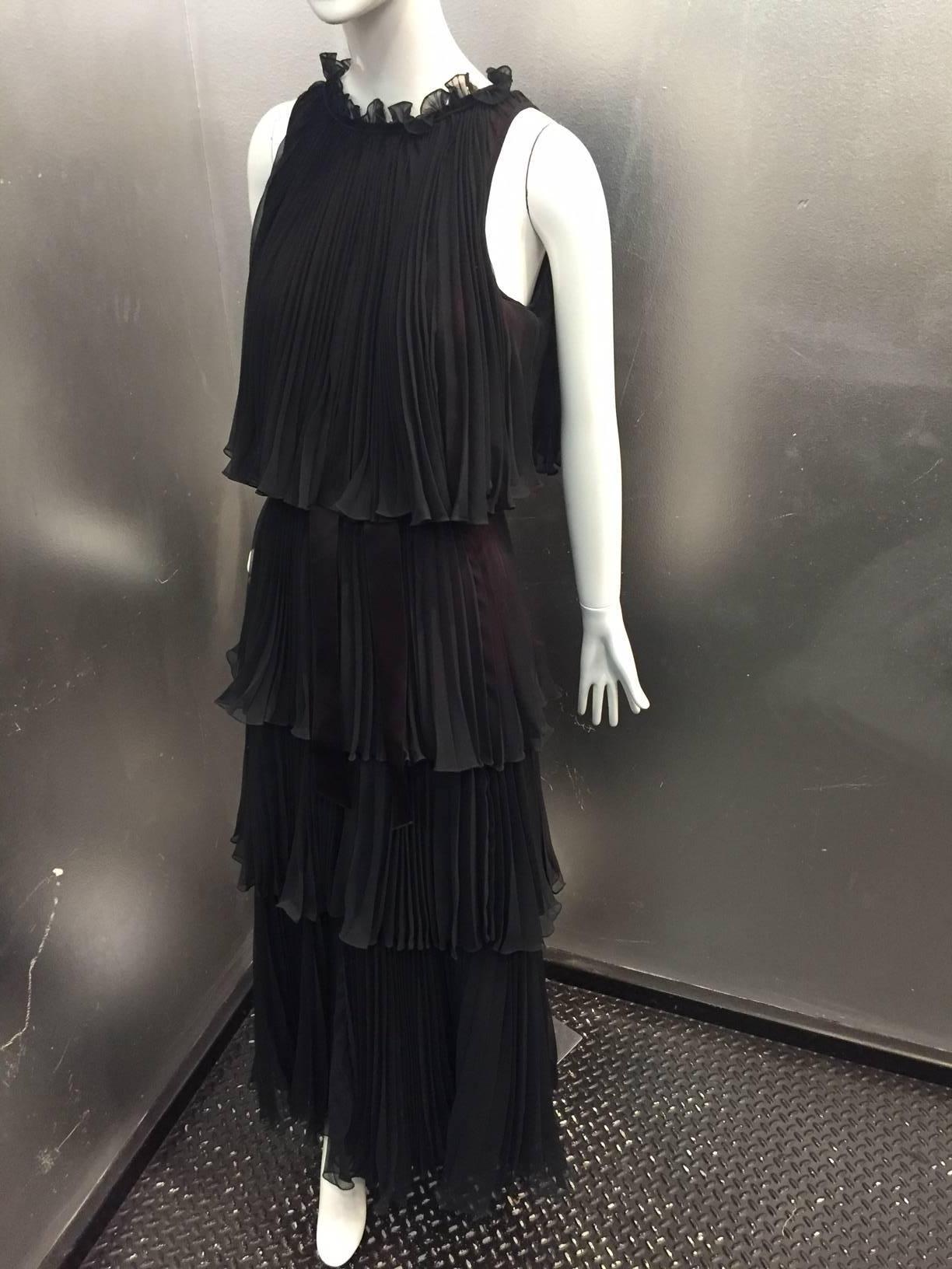 A lovely, graceful 1970s Jean Varon pleated crepe chiffon evening gown with 4 tiers.  Completely lined in a plum color acetate.  Zippered back with a small tie at top. Small ruffle at neckline. 