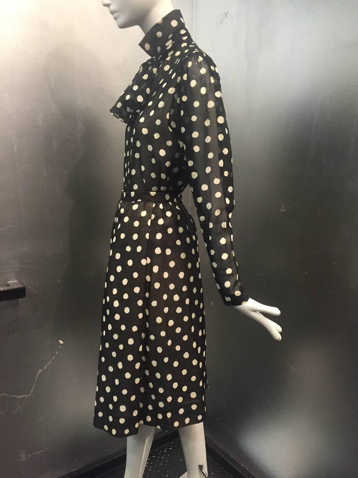 A beautiful 1970s Pauline Trigere black and white silk polka-dot print silk skirt and blouse ensemble:  Skirt has a fitted waistband, flared and knee-length with side pockets Blouse buttons down the front with a foulard at neck and zippered cuffs. 