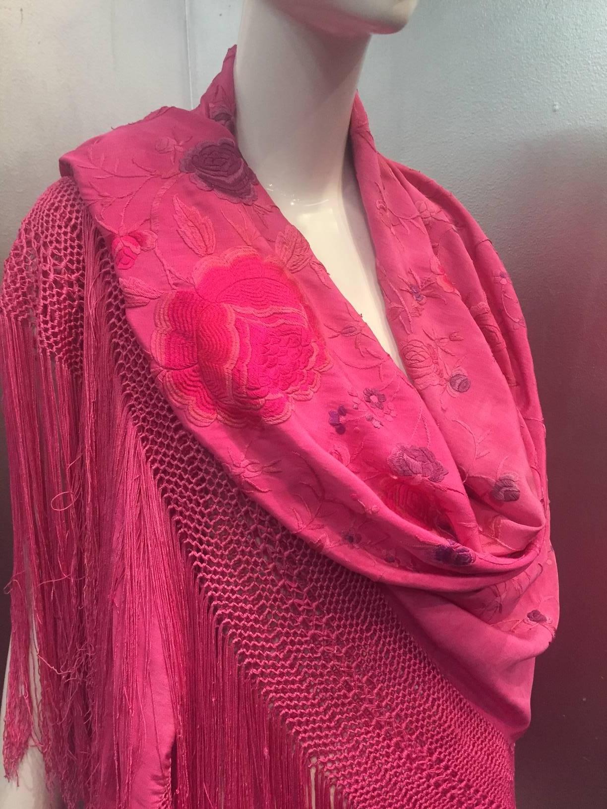 A gorgeous 1920s fuchsia over-dyed Spanish floral embroidered silk shawl with a long knotted fringe on all four sides. 