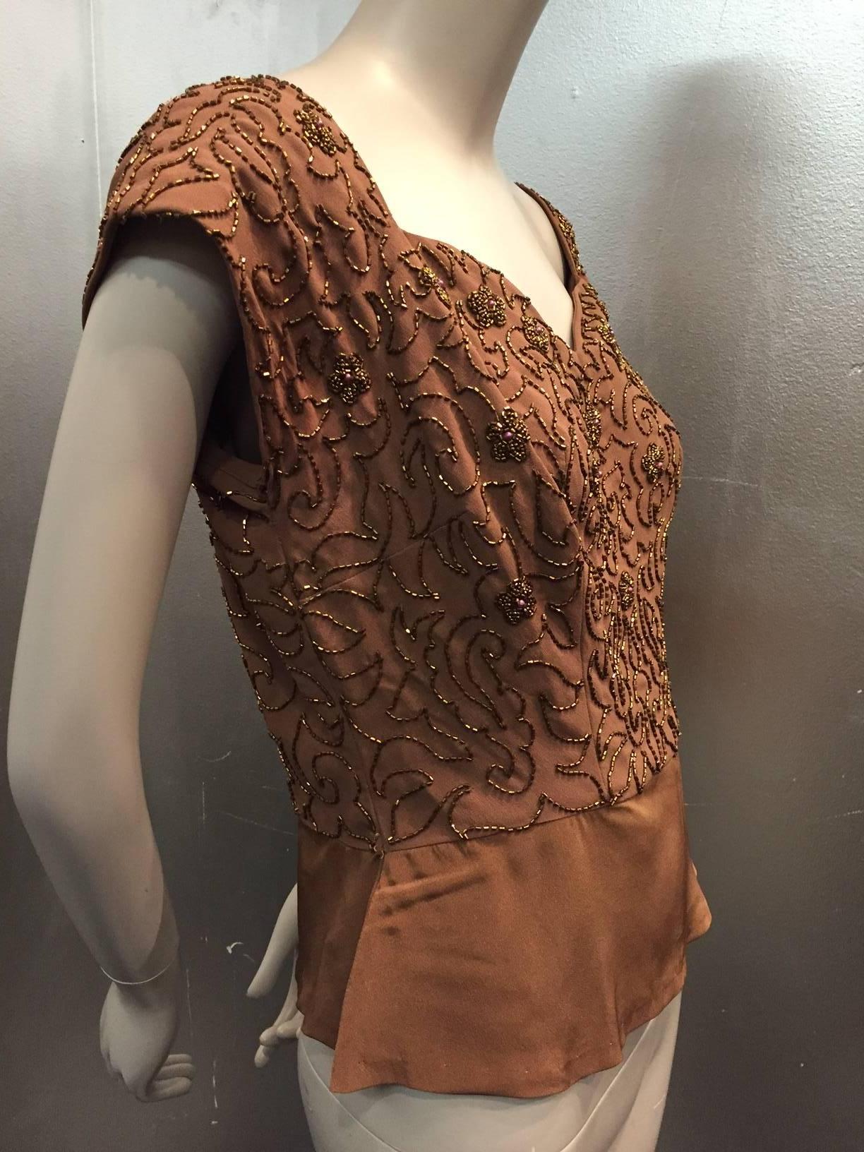 A beautiful 1950s rayon crepe evening blouse:  Mocha brown blouse with sweetheart neckline and cap sleeves entirely covered in elaborate copper beading. Short, unadorned hem is meant to be tucked in but can be worn out for a modern twist. Side