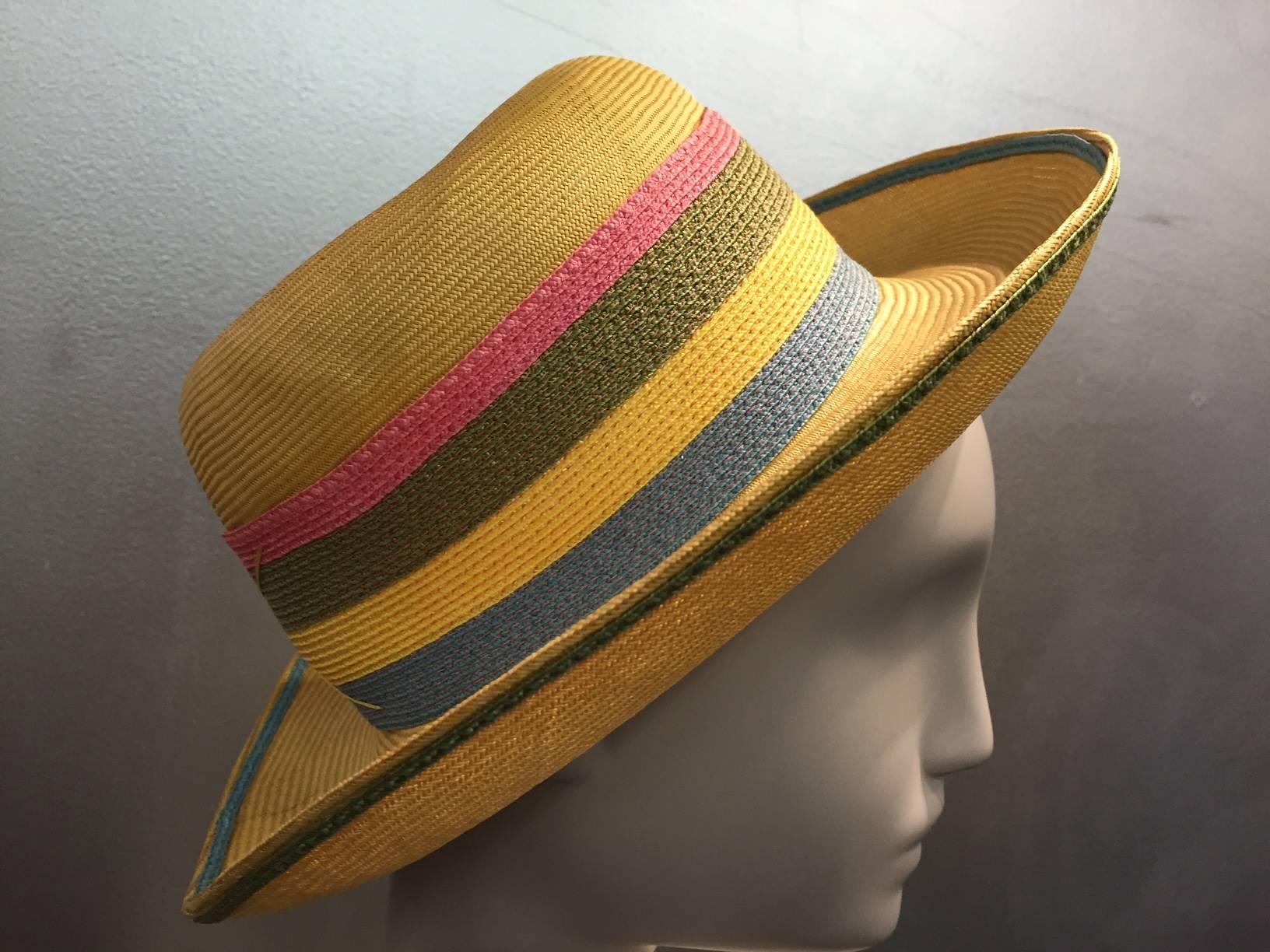 A wonderful 1960s Schiaparelli yellow straw brimmed hat w/ striped straw band in pink, green and steel blue. 
